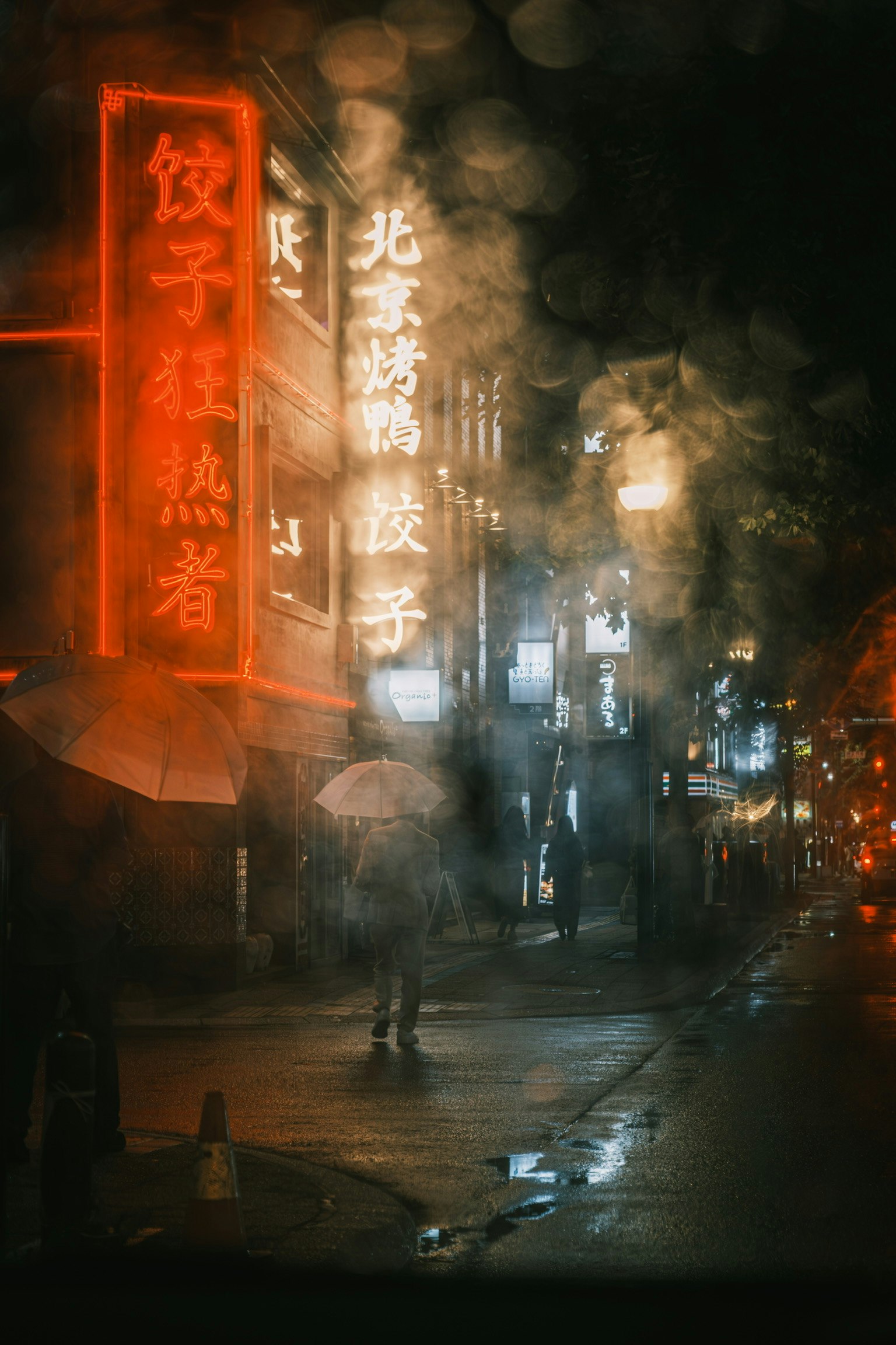 霧のかかった夜の街並みに赤いネオン看板が輝く