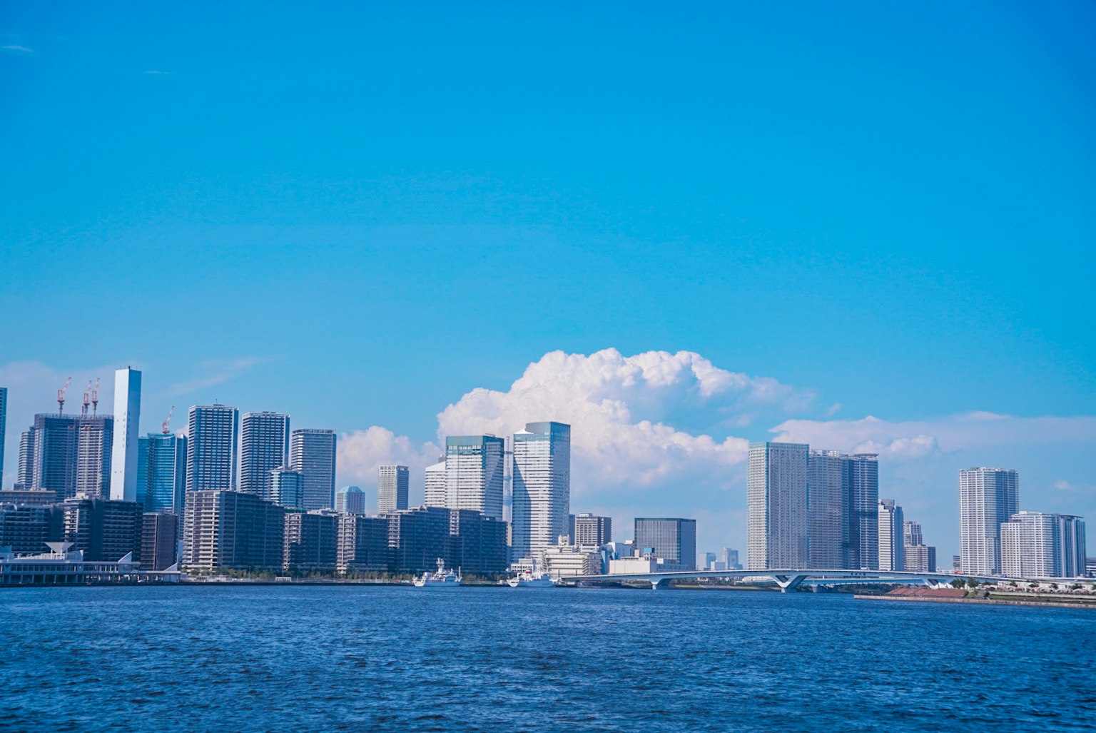 City skyline under a blue sky with calm waters