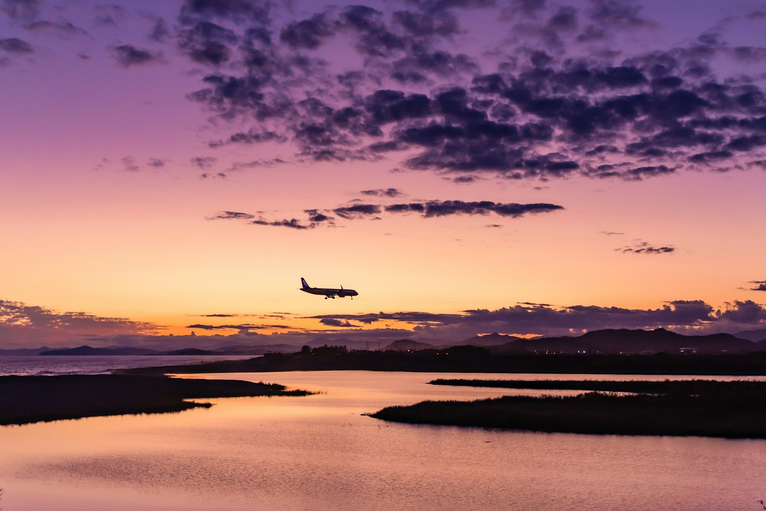 Aereo che atterra contro un bellissimo cielo al tramonto