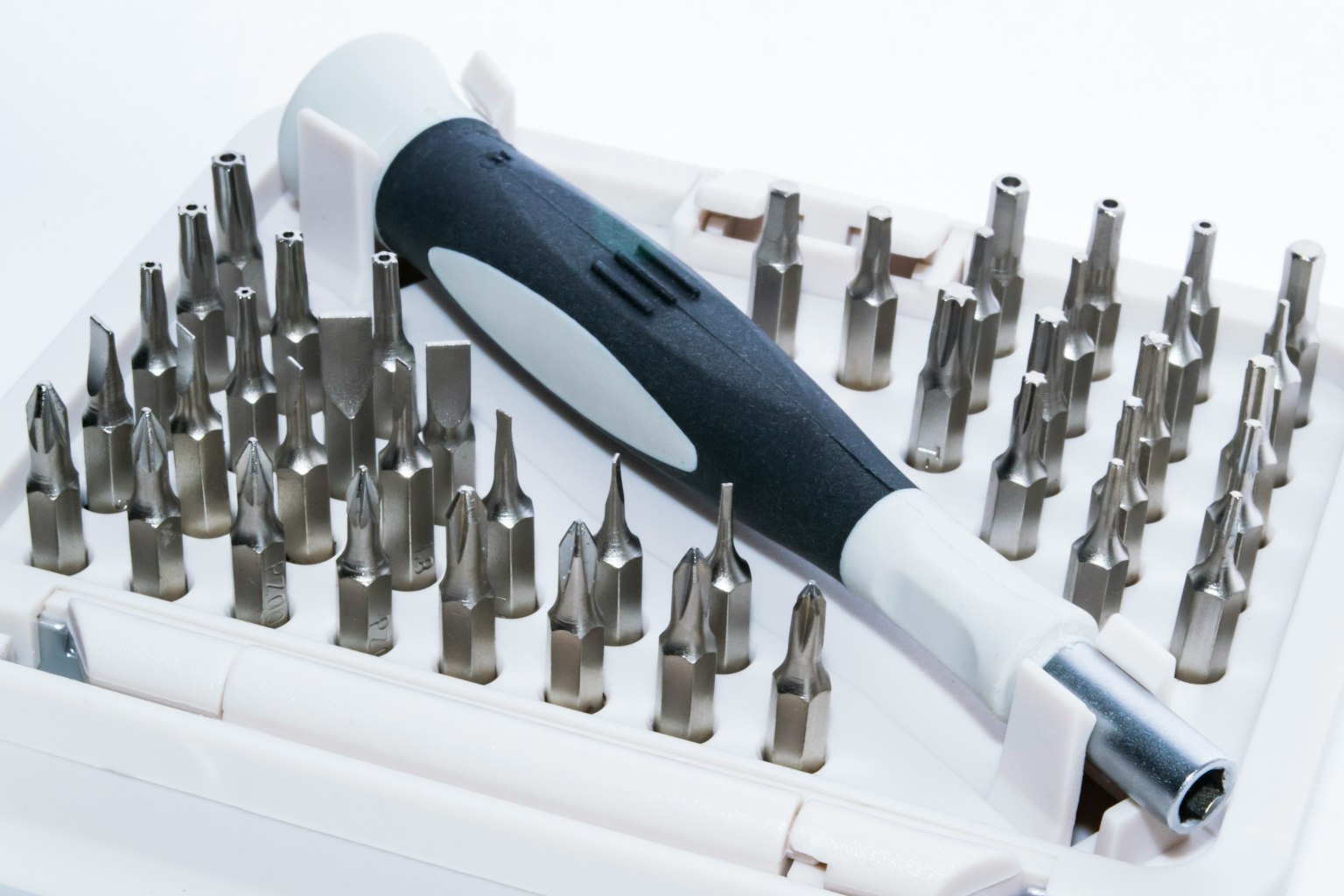 Set di attrezzi con vari bit per cacciavite e un manico bianco e nero