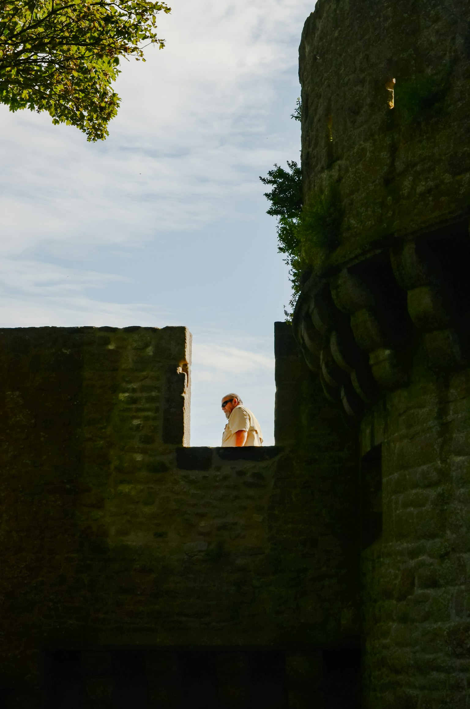 古い城の壁の上に立つ人影と青空