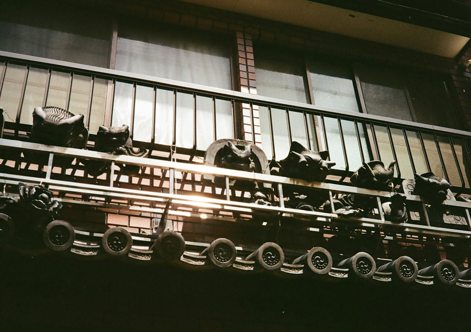 Bánh xe đen được sắp xếp trên ban công của một tòa nhà cũ với ánh sáng mặt trời phản chiếu qua cửa sổ