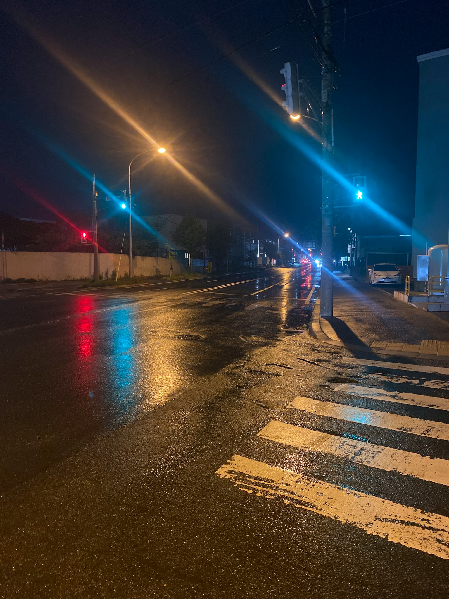 夜間街角濕滑的路面和交通信號燈的反射