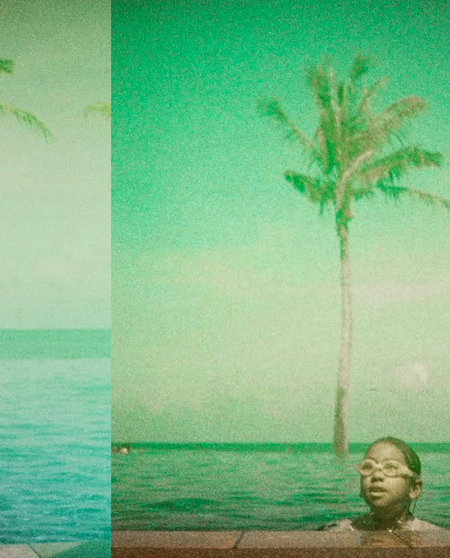 Enfant dans une piscine avec vue sur l'océan et des palmiers
