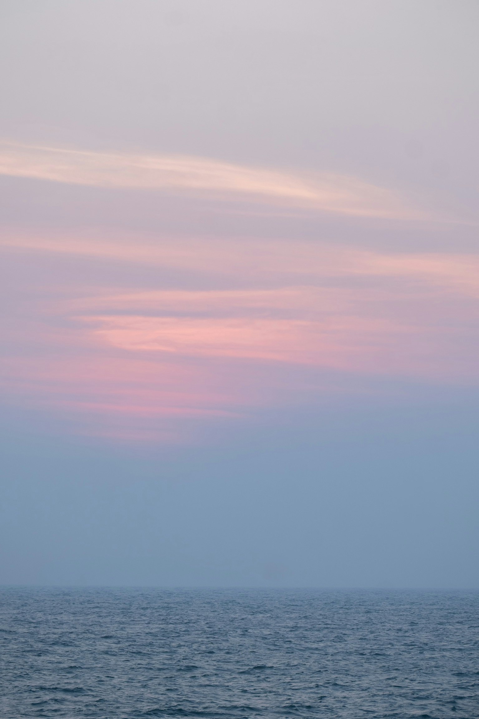 平静的海面与柔和的粉彩天空在黄昏时分