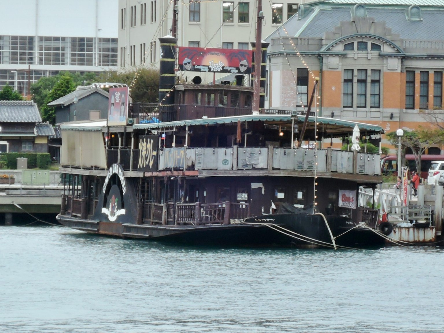 Sebuah kapal uap hitam berlabuh di pelabuhan