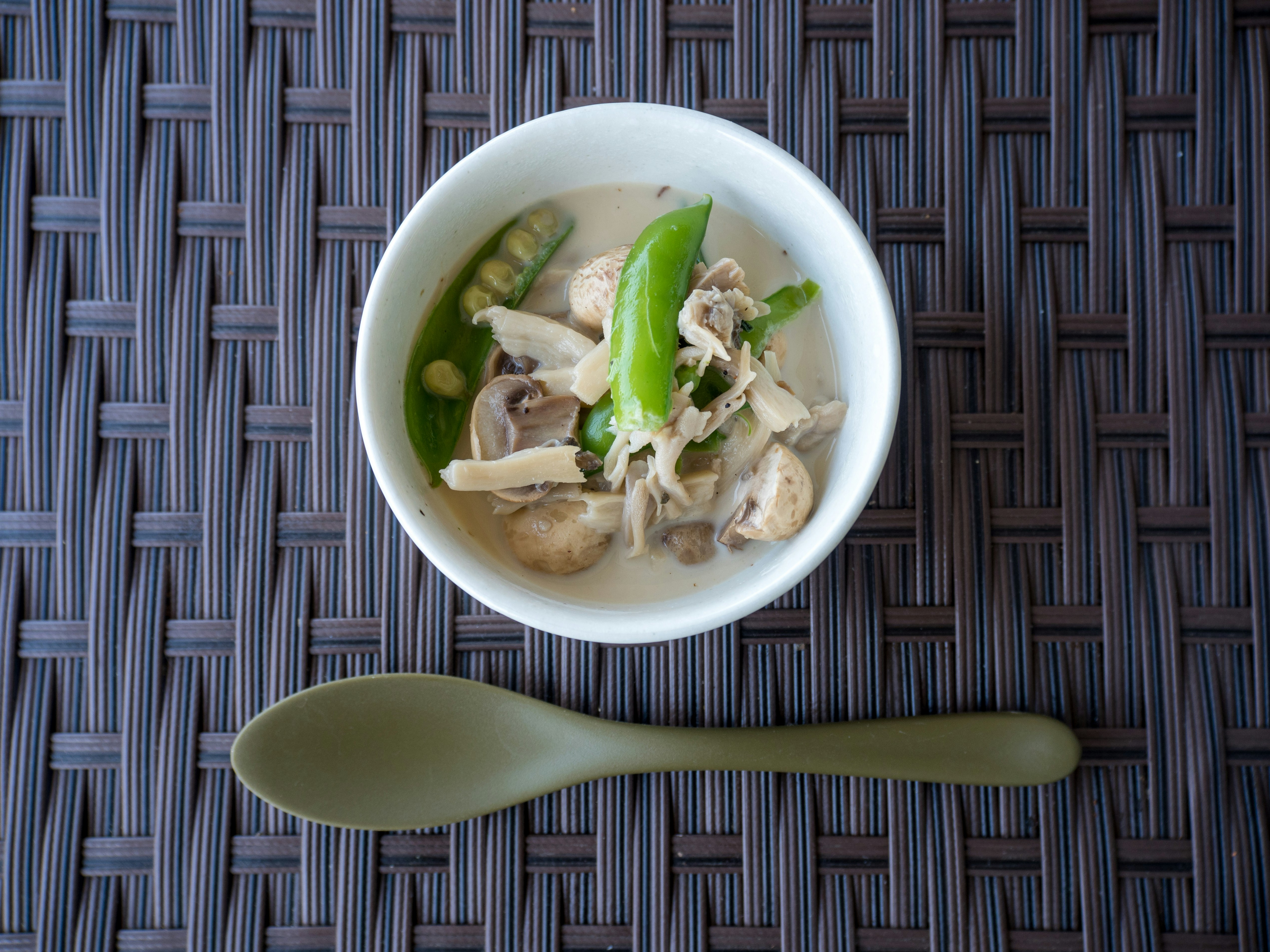 ciotola di brodo di pollo con cipollotto verde e funghi