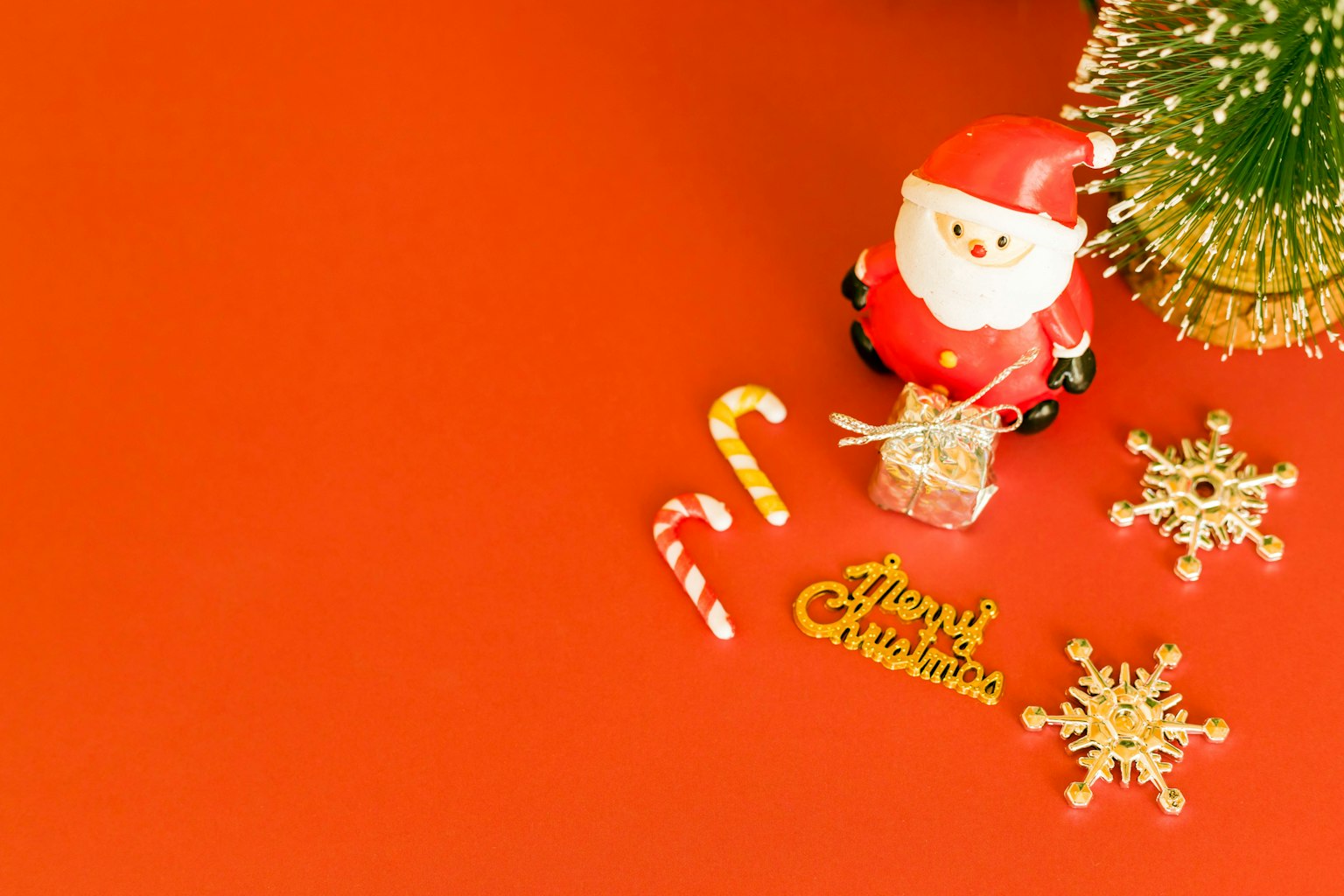 Figura di Babbo Natale con bastoncini di zucchero e decorazioni natalizie su uno sfondo rosso