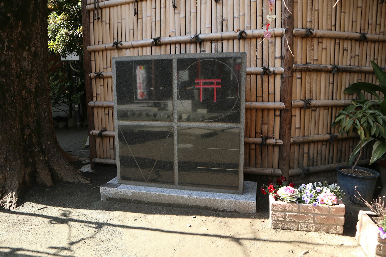 Panneau transparent montrant un torii contre un fond en bambou