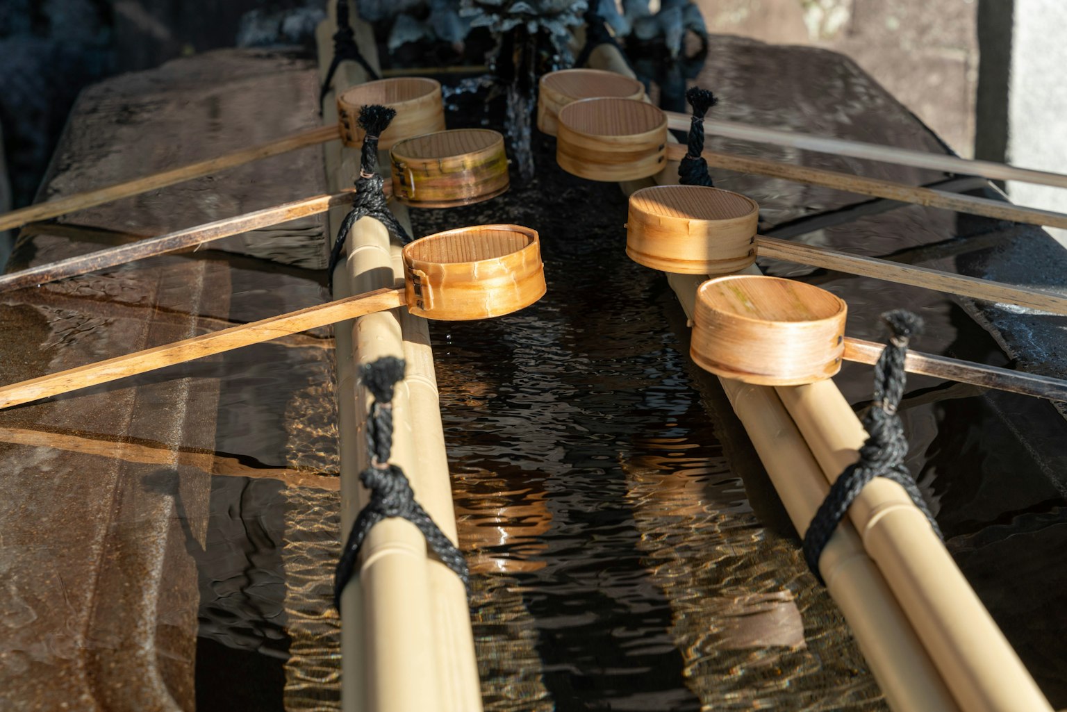 Bamboo poles and wooden ladles arranged over water