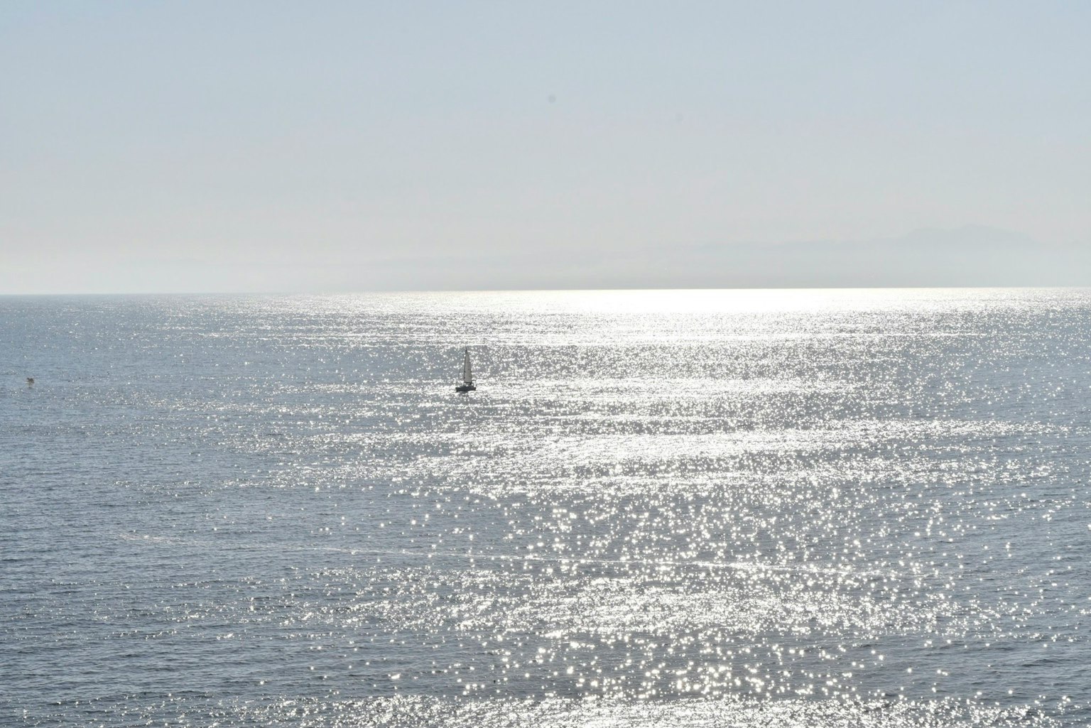 Una piccola barca che galleggia su un mare calmo con riflessi di sole