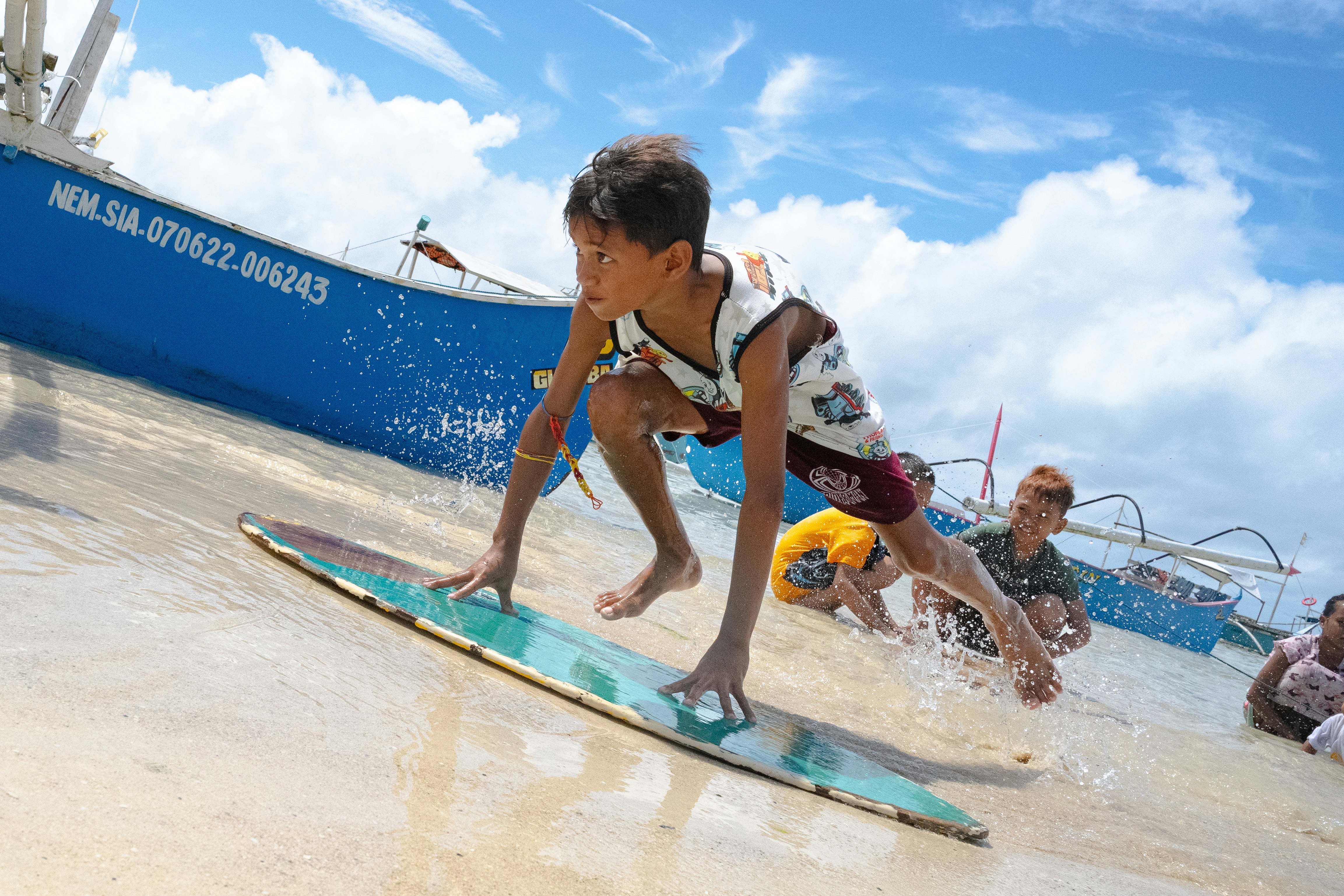ビーチでサーフボードに乗る子どもたちの夏の波遊び