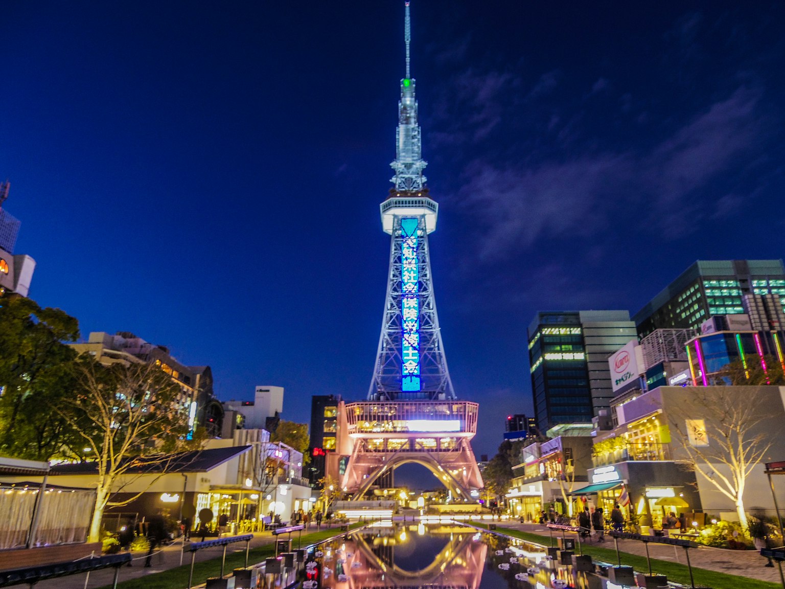Nagoya Fernsehturm bei Nacht beleuchtet mit Spiegelungen im Wasser