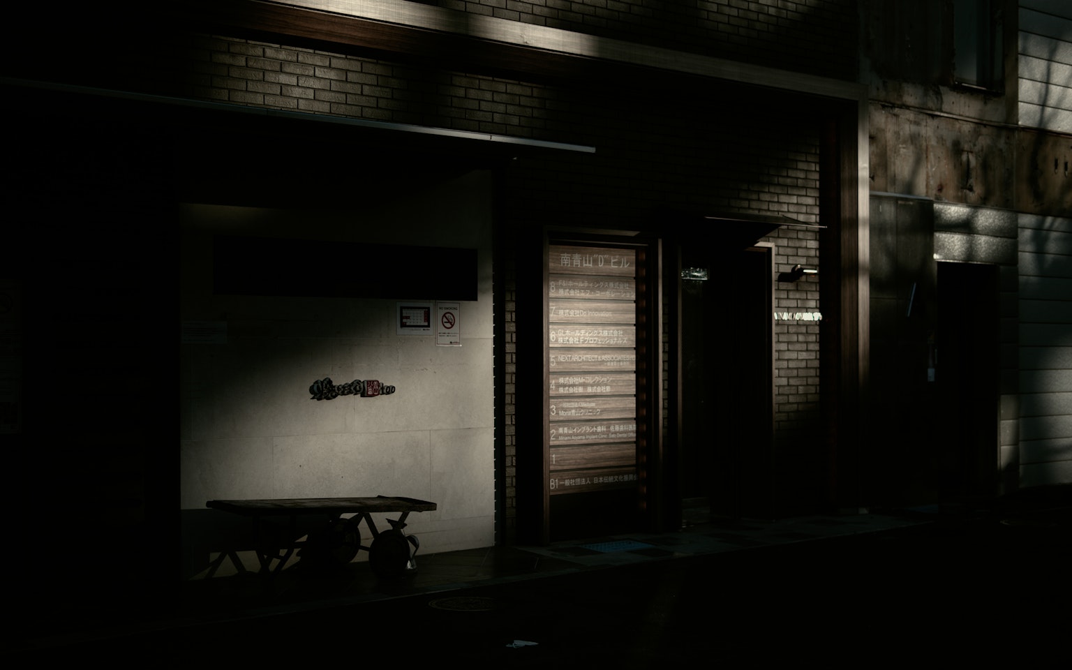 Exterior view of a house on a dimly lit street with a wooden bench