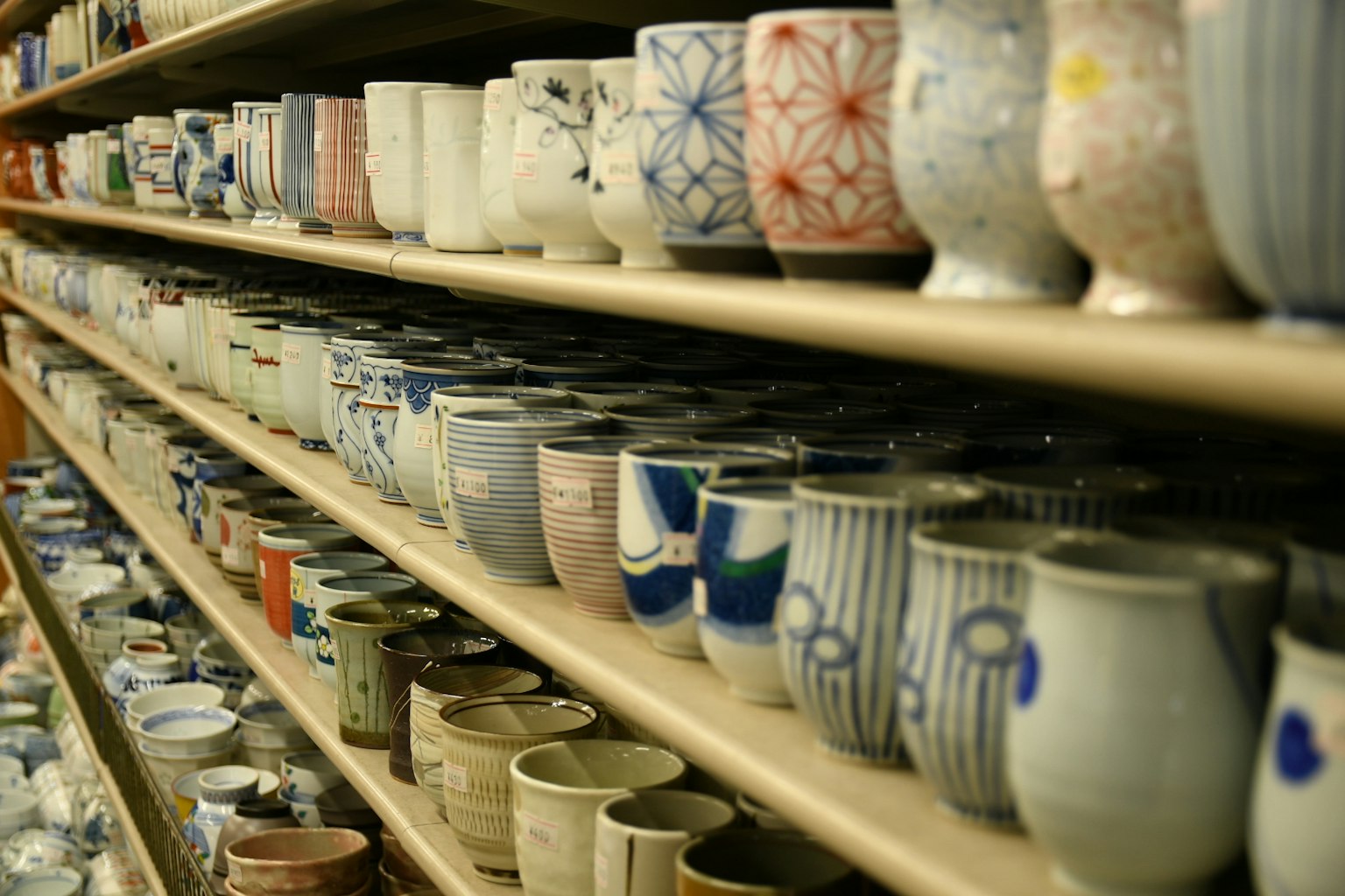 Una varietà di tazze in ceramica disposte ordinatamente su scaffali