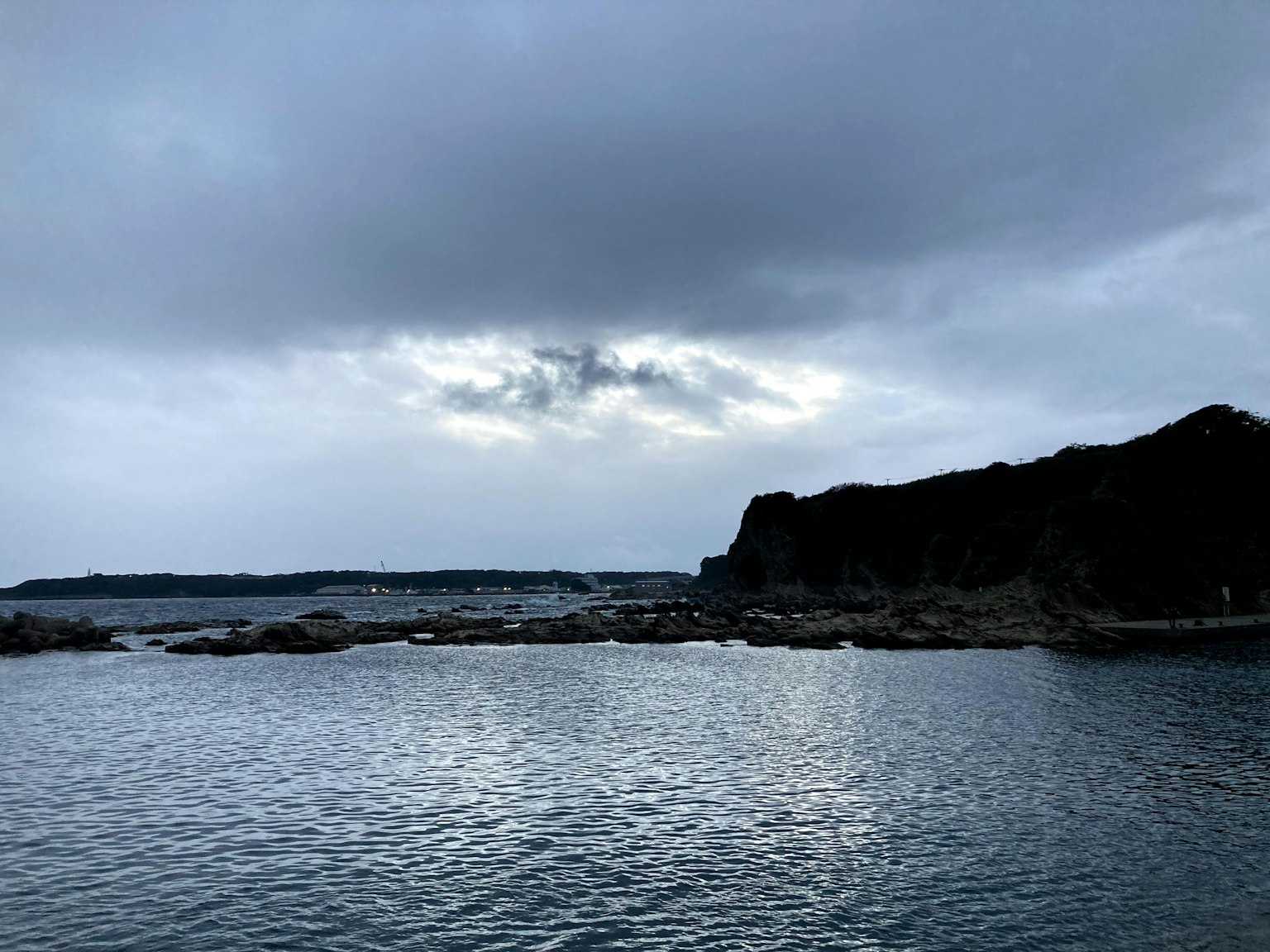 Vista escénica del océano y las rocas bajo un cielo nublado
