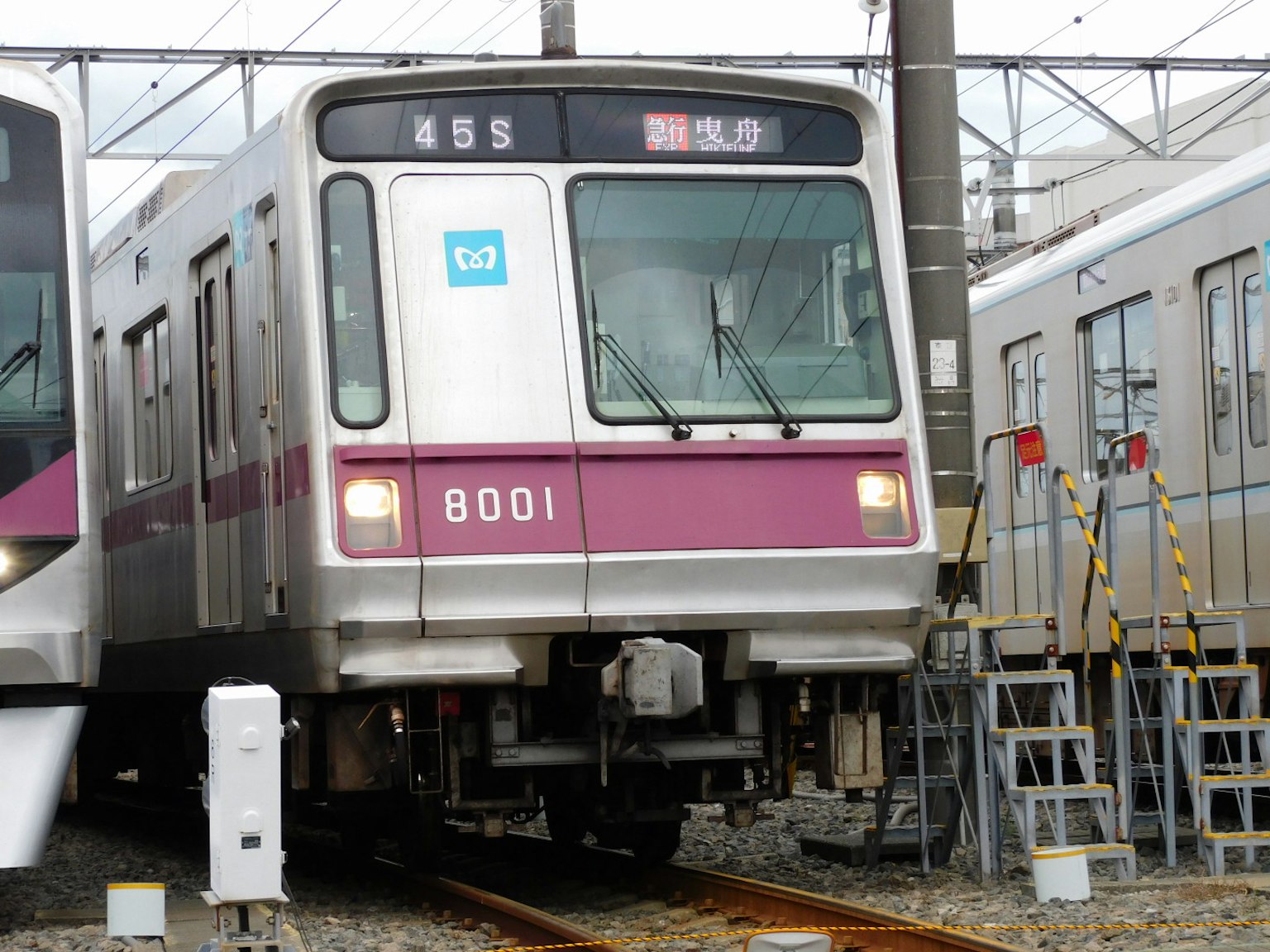 Kereta nomor 8001 di stasiun dengan rel dekat