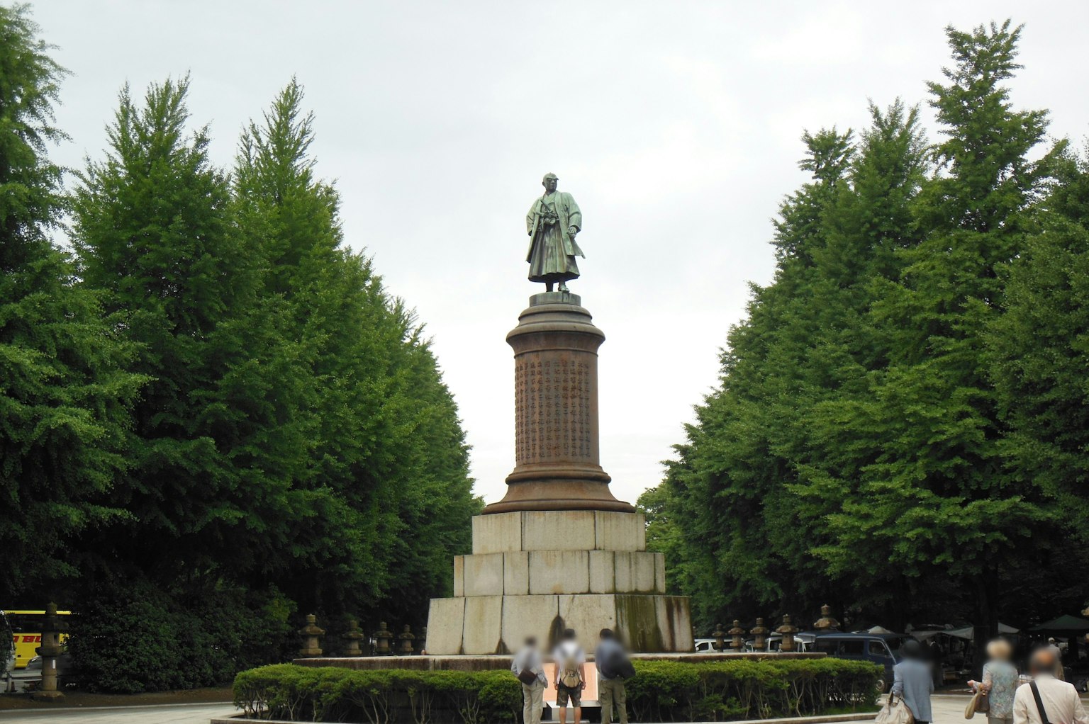 Estatua en el centro de un parque rodeada de árboles verdes