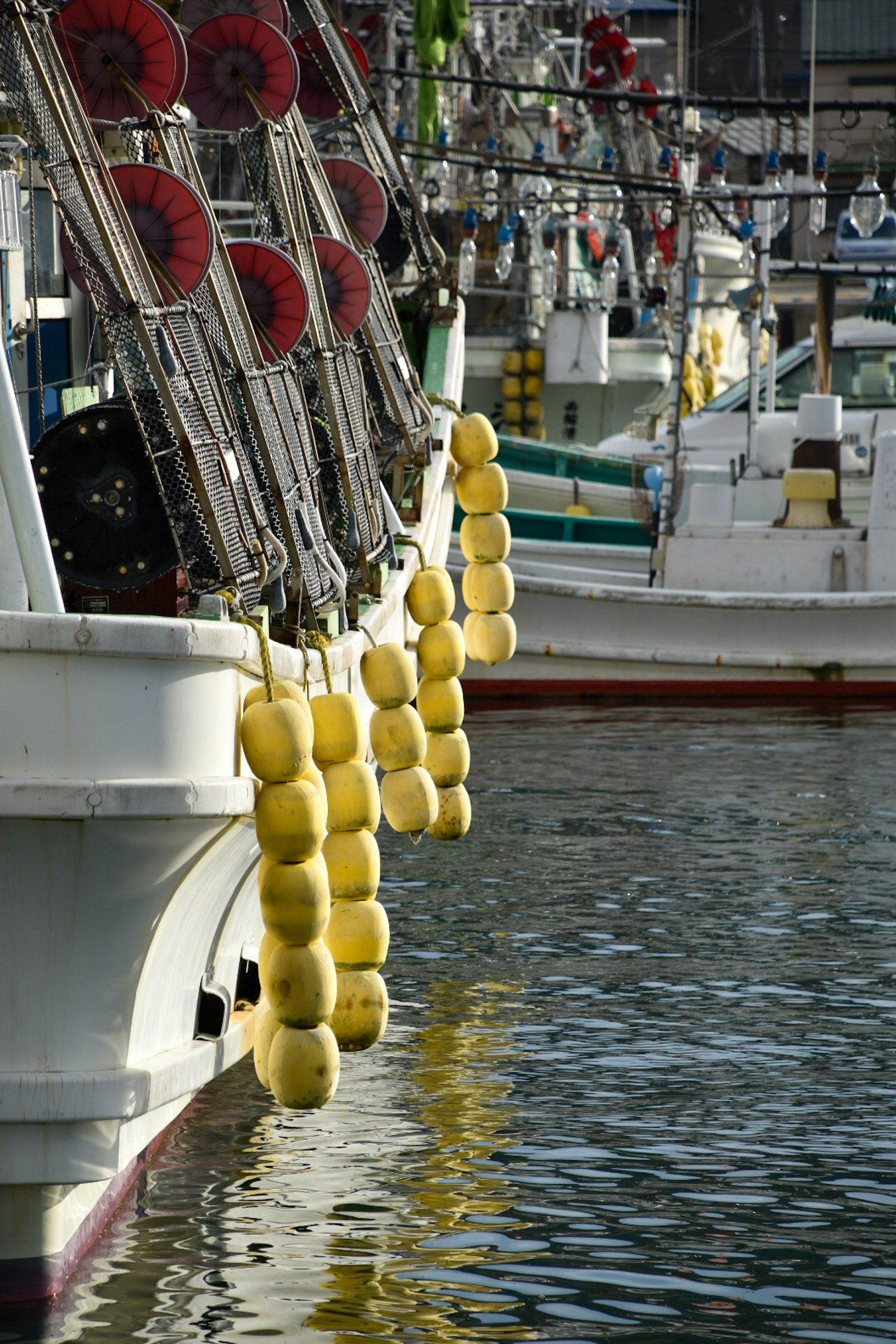 Bouées jaunes suspendues sur le côté des bateaux de pêche dans le port