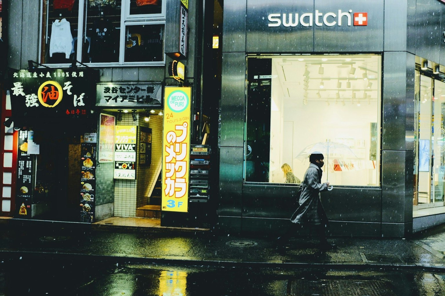 คนเดินอยู่หน้าร้าน Swatch ในสภาพแวดล้อมเมืองยามค่ำคืน