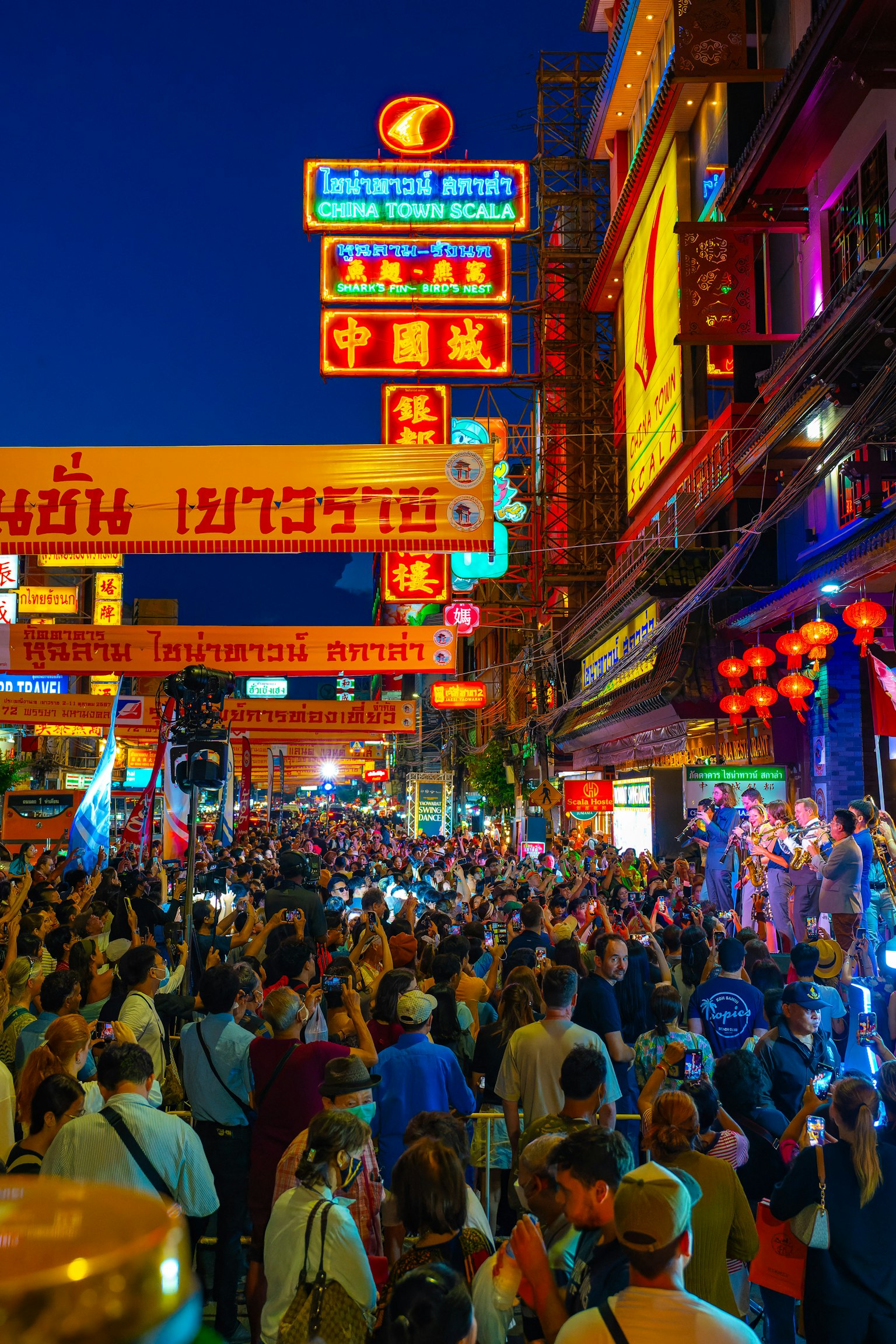 熱鬧的夜晚唐人街街道，聚集著人群和五彩斑斕的霓虹燈牌