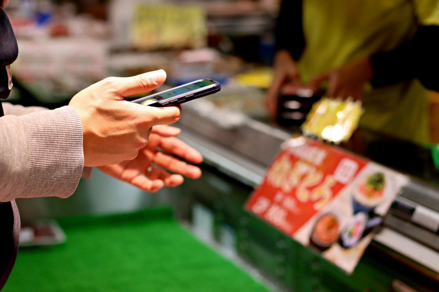 Personne tenant un smartphone avec un menu alimentaire à un stand de marché