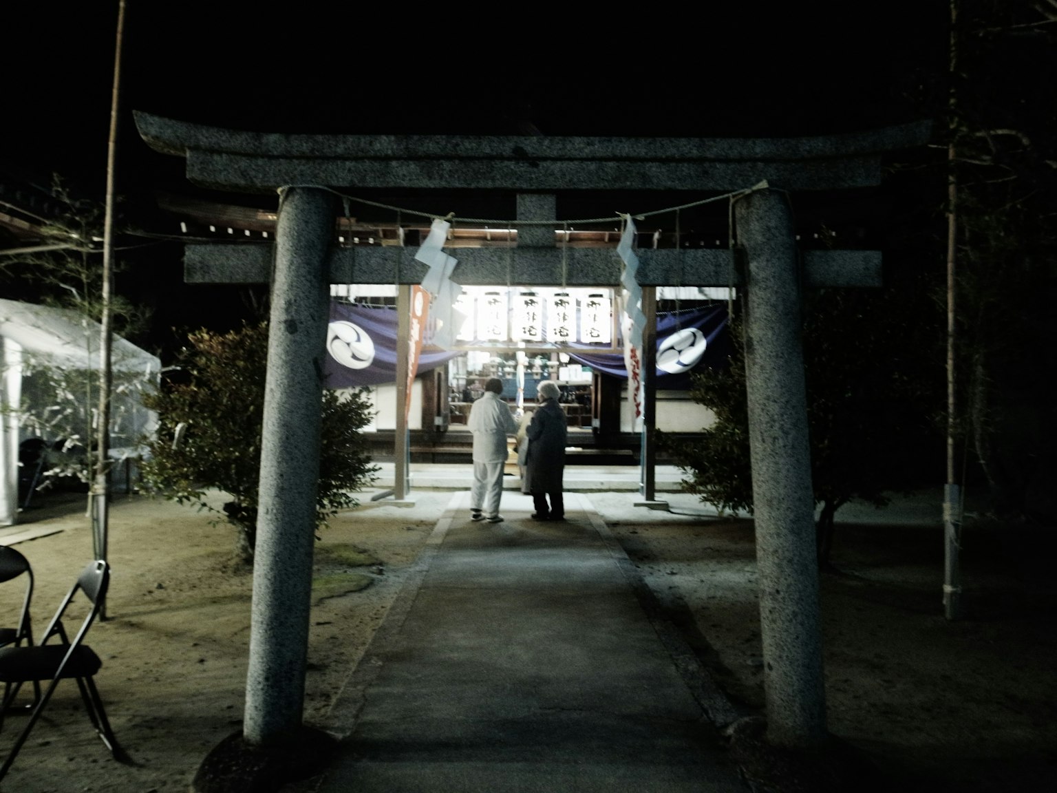Portale Torii di notte con persone davanti a un santuario