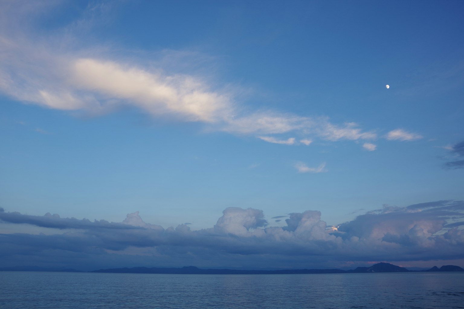 Cielo blu con nuvole e luna visibile