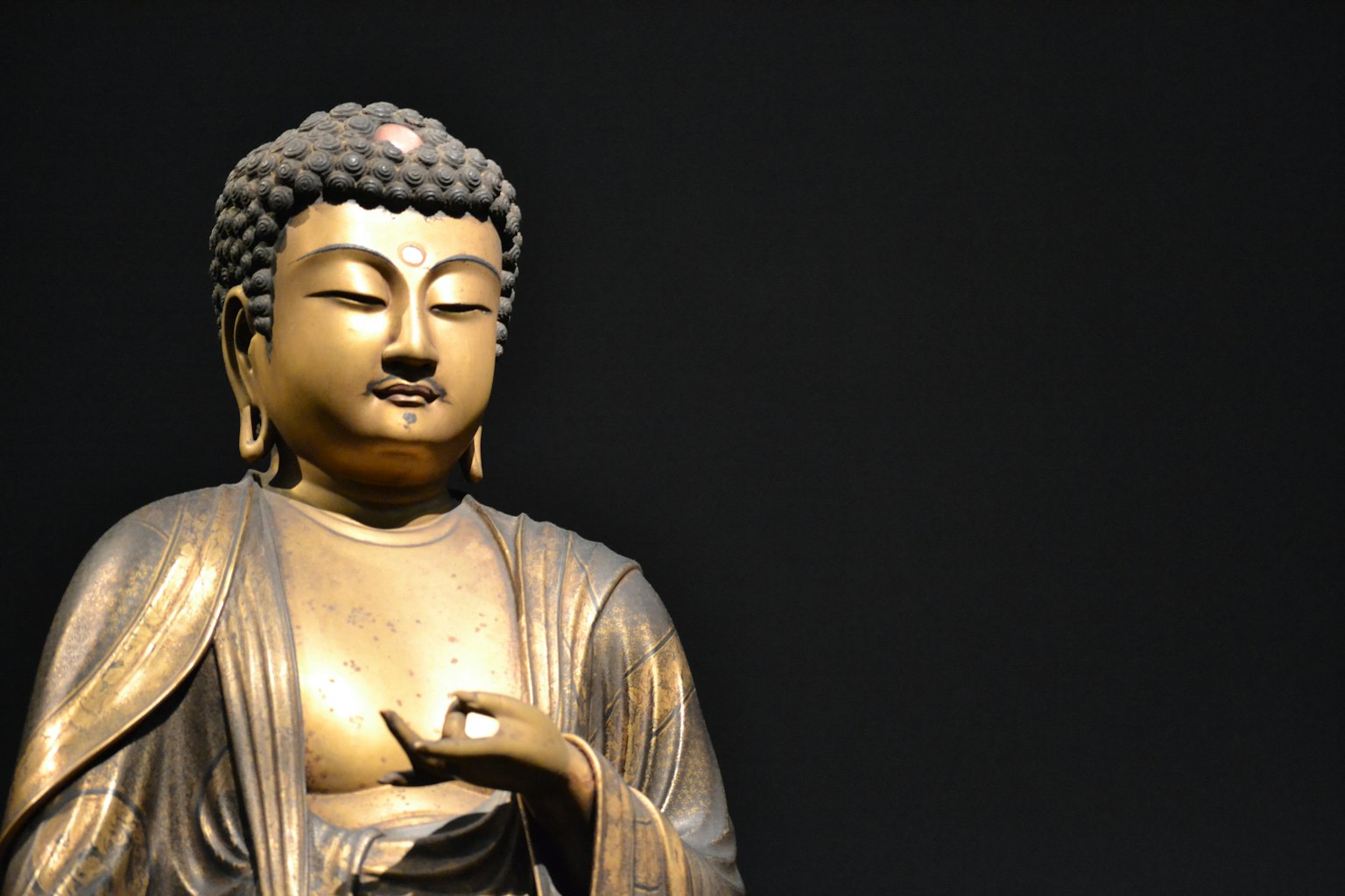 Statua di Buddha dorata su uno sfondo nero