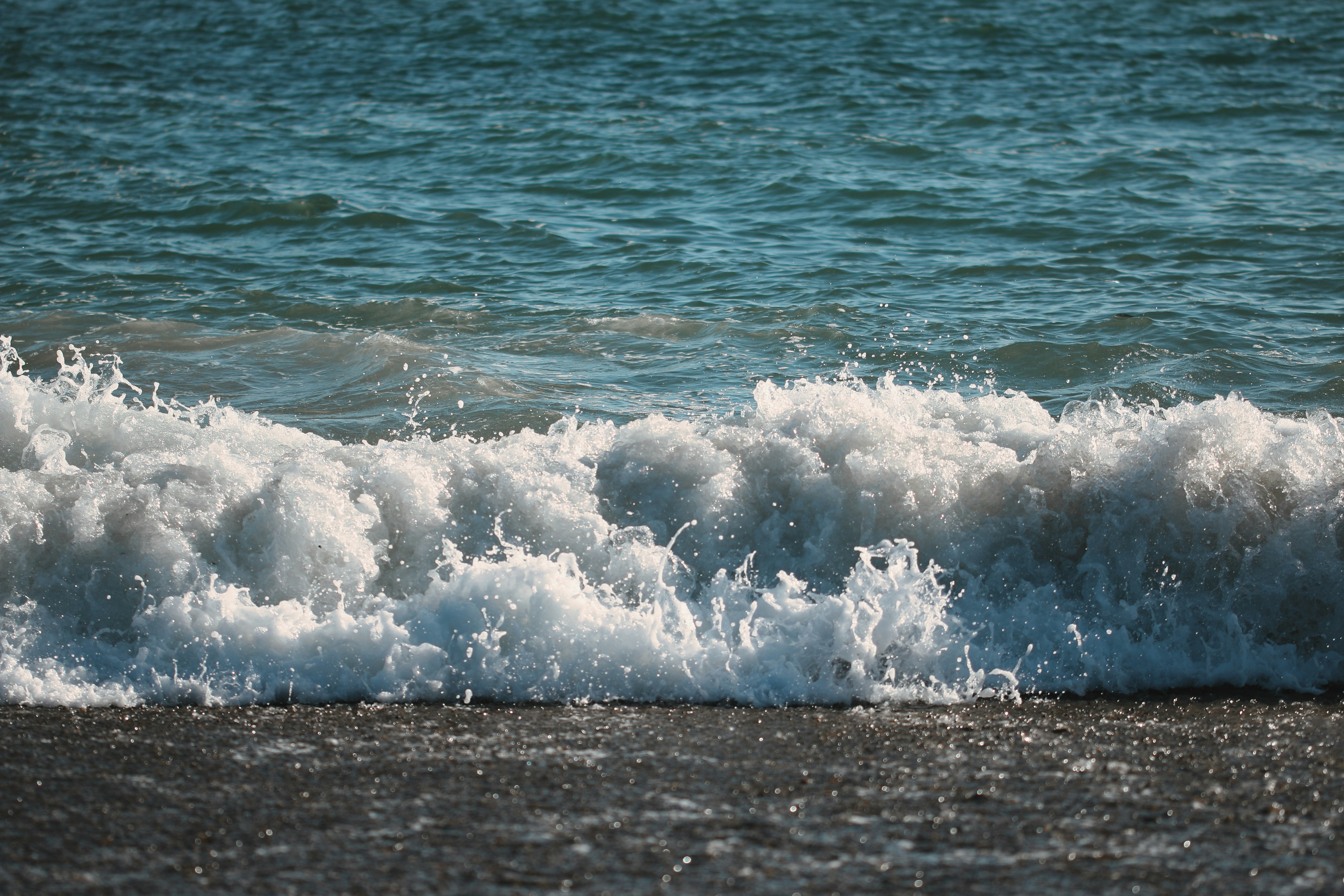 Waves crashing on a beach with clear blue water