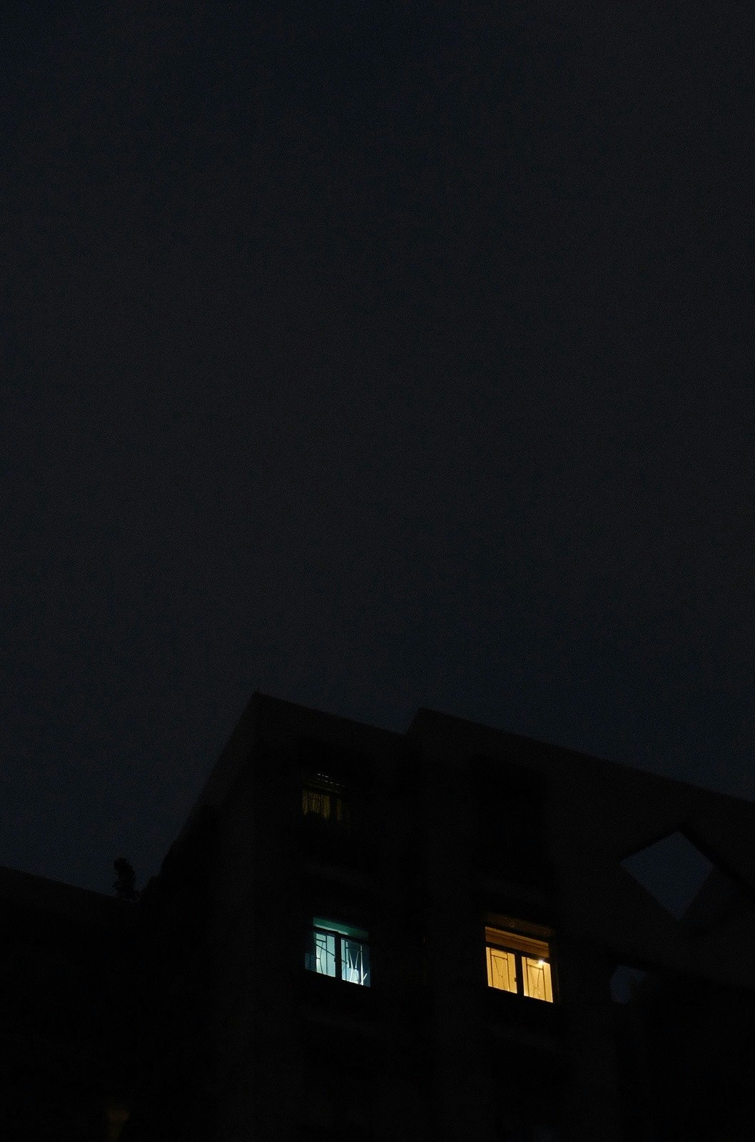 夜の住宅街に浮かぶ窓明かりのある家の外観