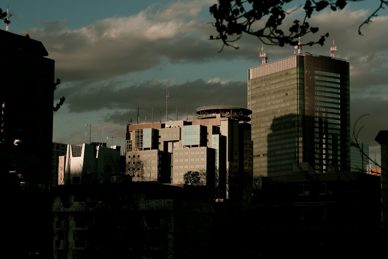 Siluetas de rascacielos urbanos al anochecer con nubes dramáticas