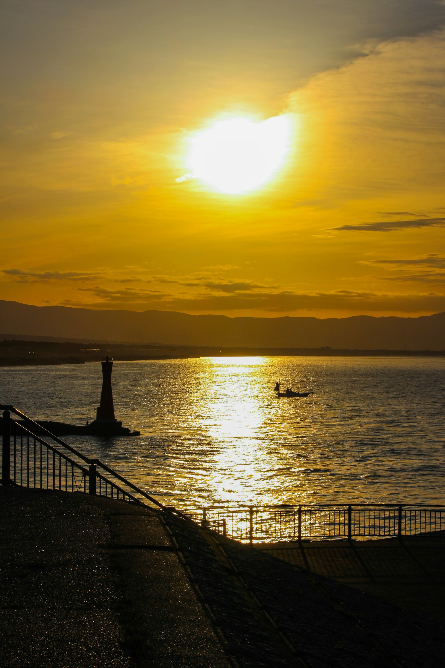Bellissimo tramonto che si riflette sul mare con una barca in lontananza