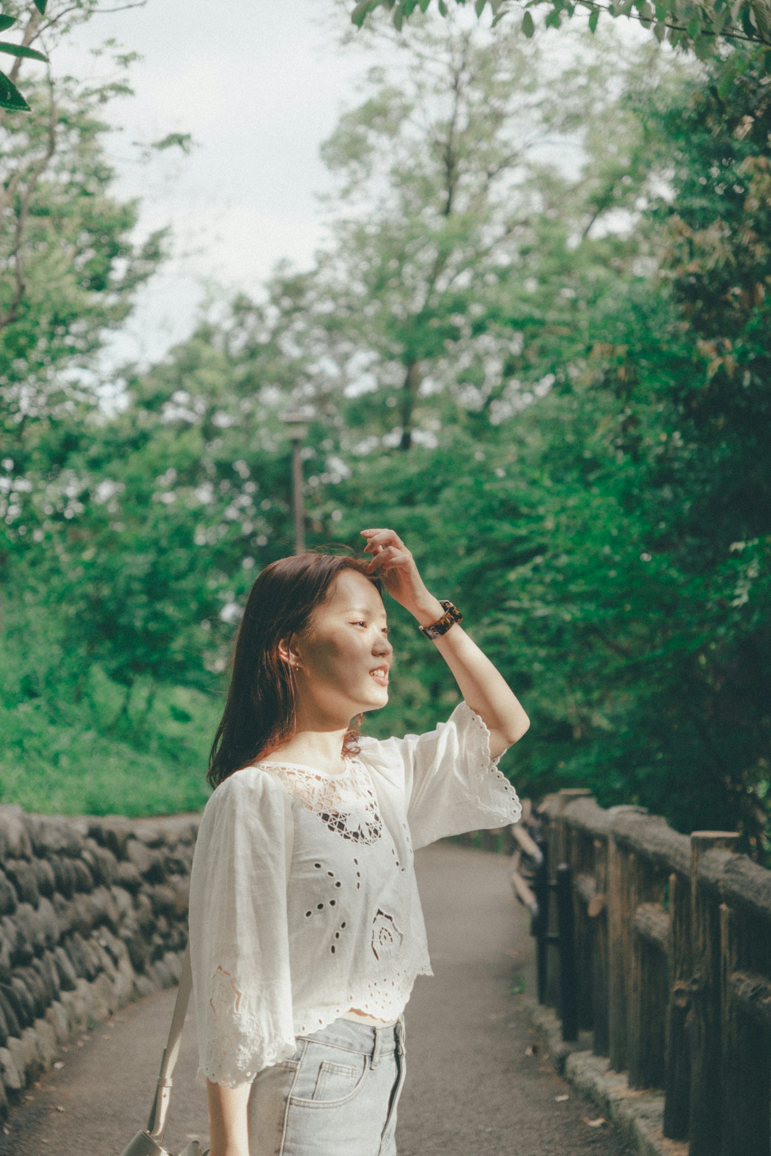 一位女性走在郁郁葱葱的小路上
