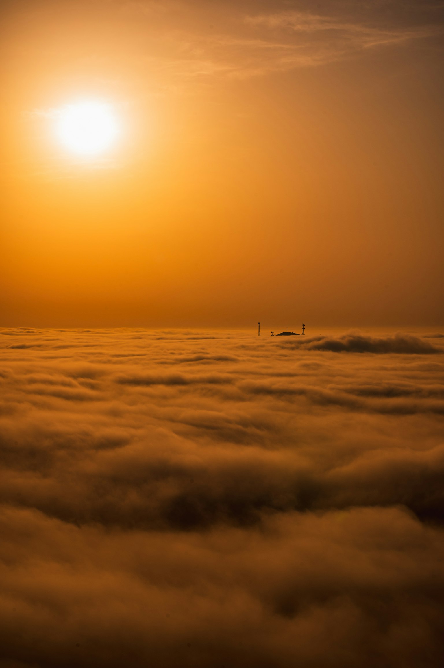 Une belle vue de coucher de soleil avec le soleil brillant au-dessus d'une mer de nuages