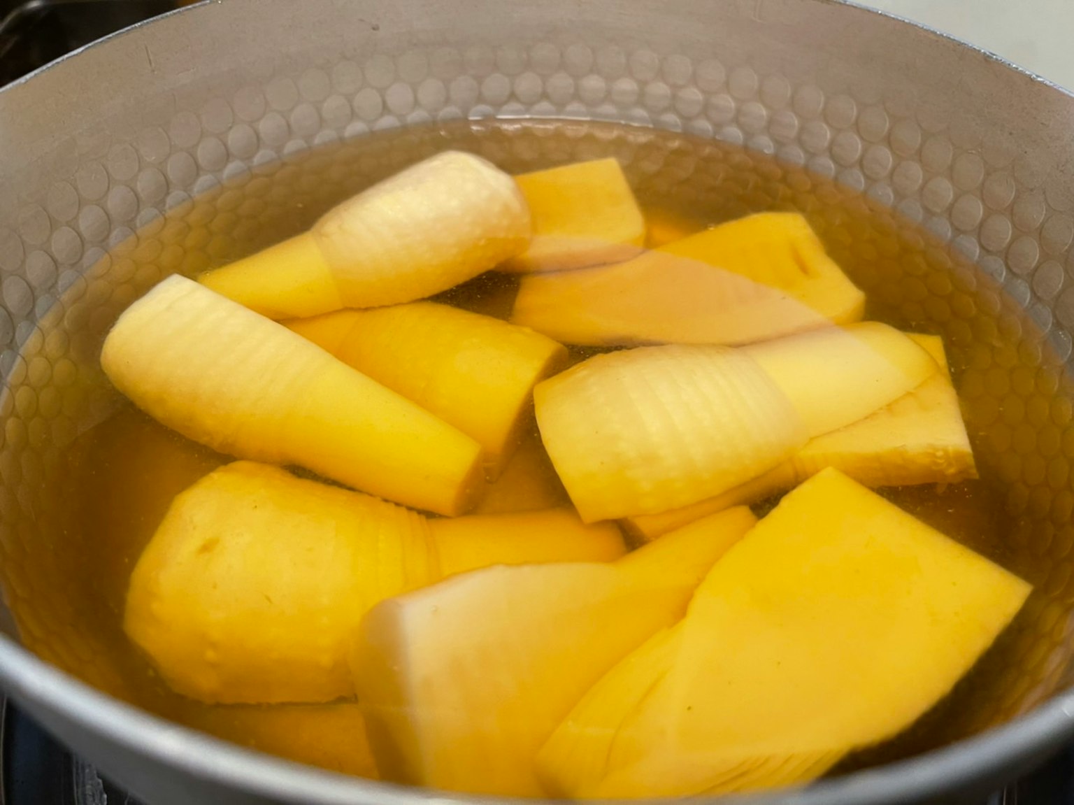 Slices of yellow bananas boiling in a pot