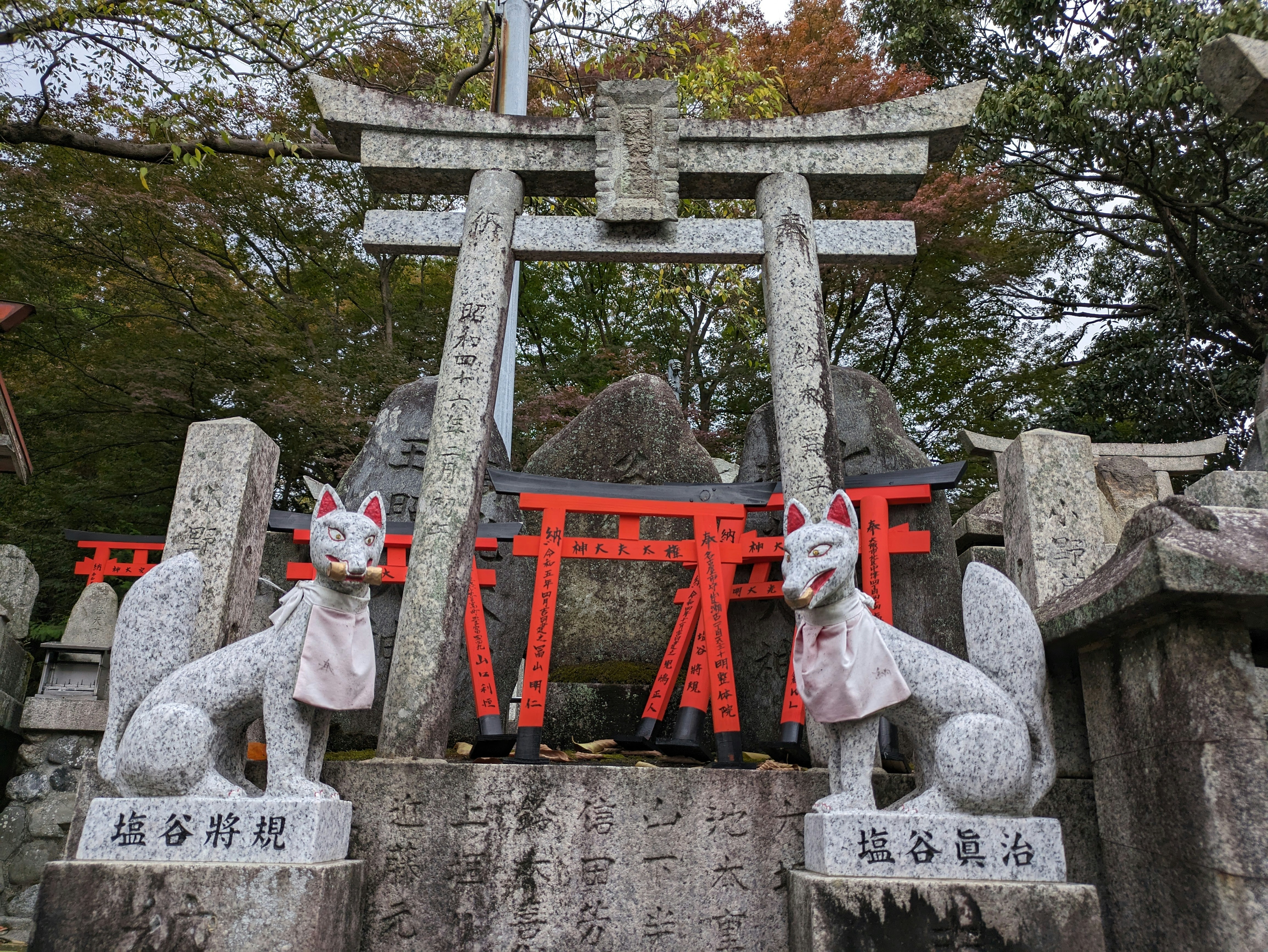 京都的狐狸雕像与鸟居前的石碑