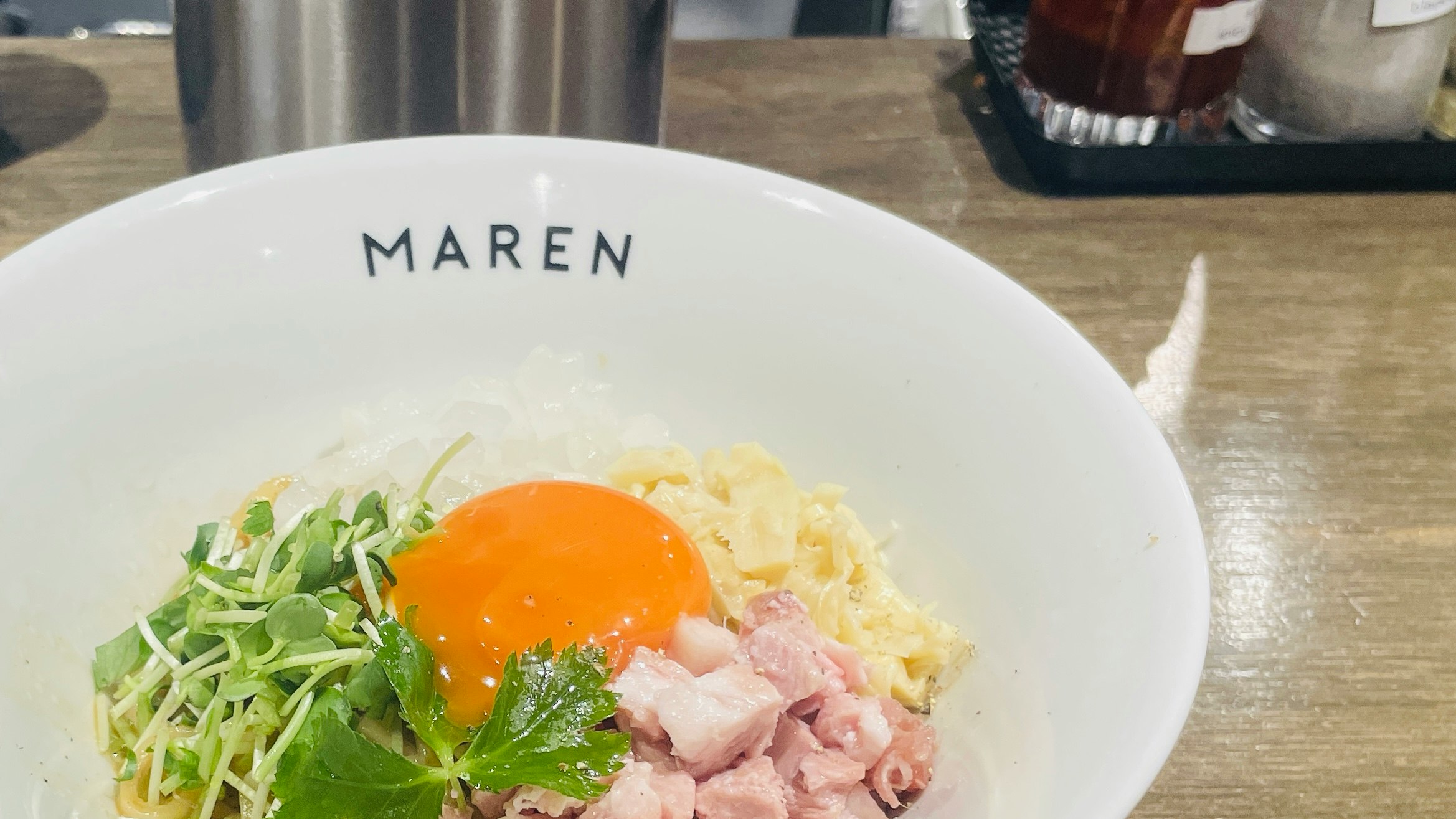 木製テーブルの上の白い皿に盛られた朝食プレート