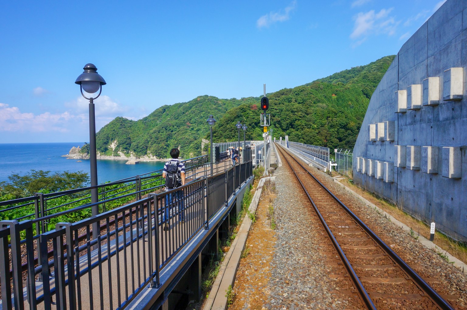 Vue pittoresque d'une gare avec un arrière-plan océanique et des montagnes