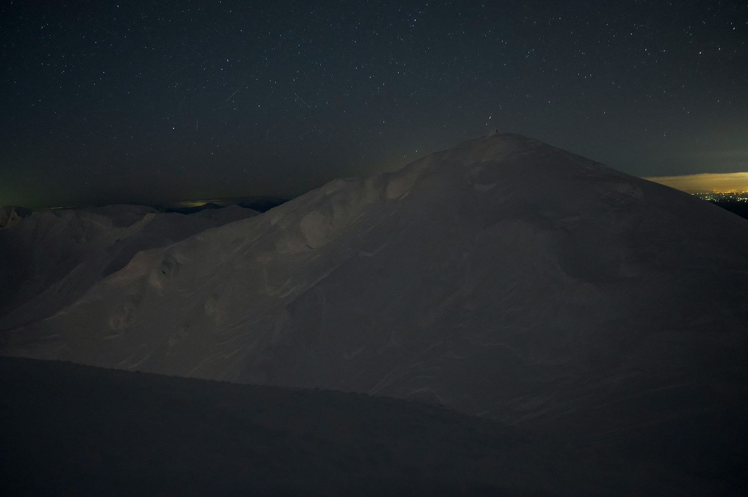 Quiet landscape of a snow-covered mountain under the night sky
