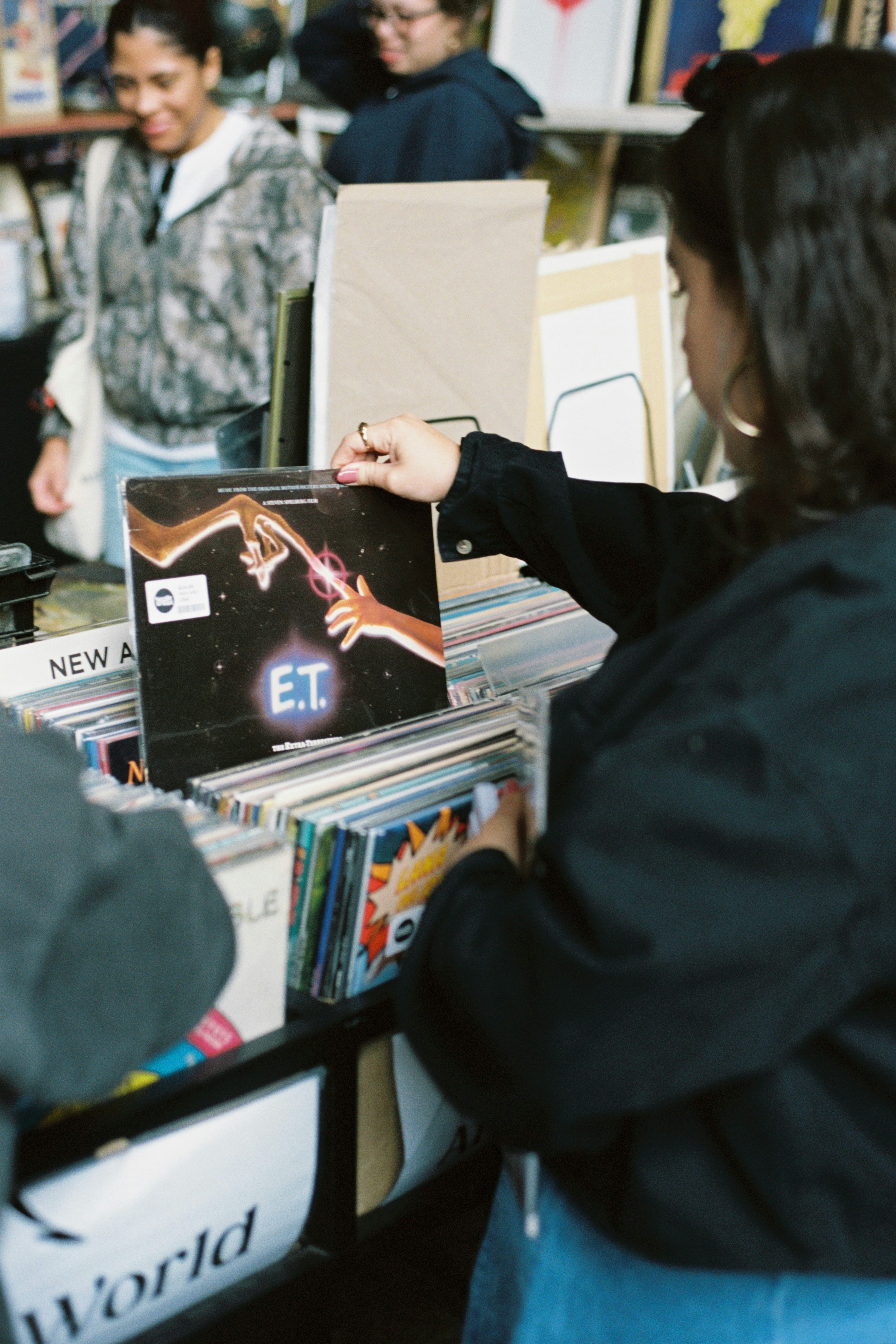 書店の棚でE.T.の関連本を手に取る人々のある店内