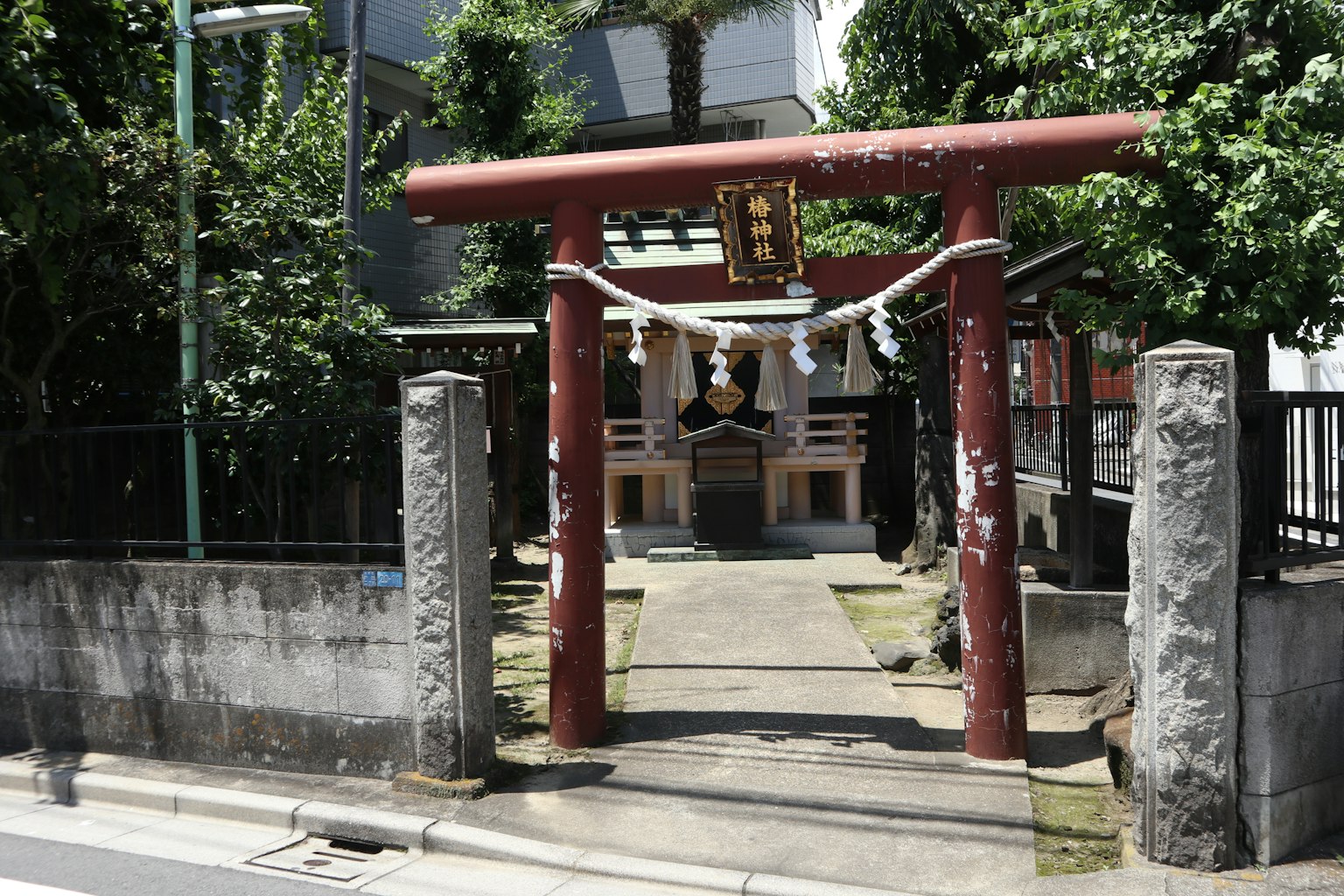 Entrada de un santuario con un torii rojo y vegetación exuberante