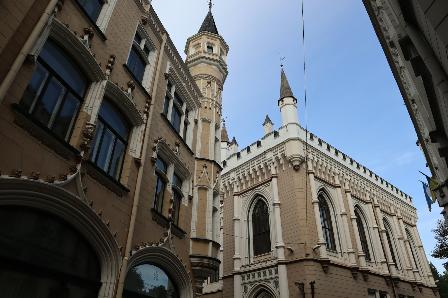 Straßenecke mit schöner Architektur und Türmen und Spitzen vor blauem Himmel