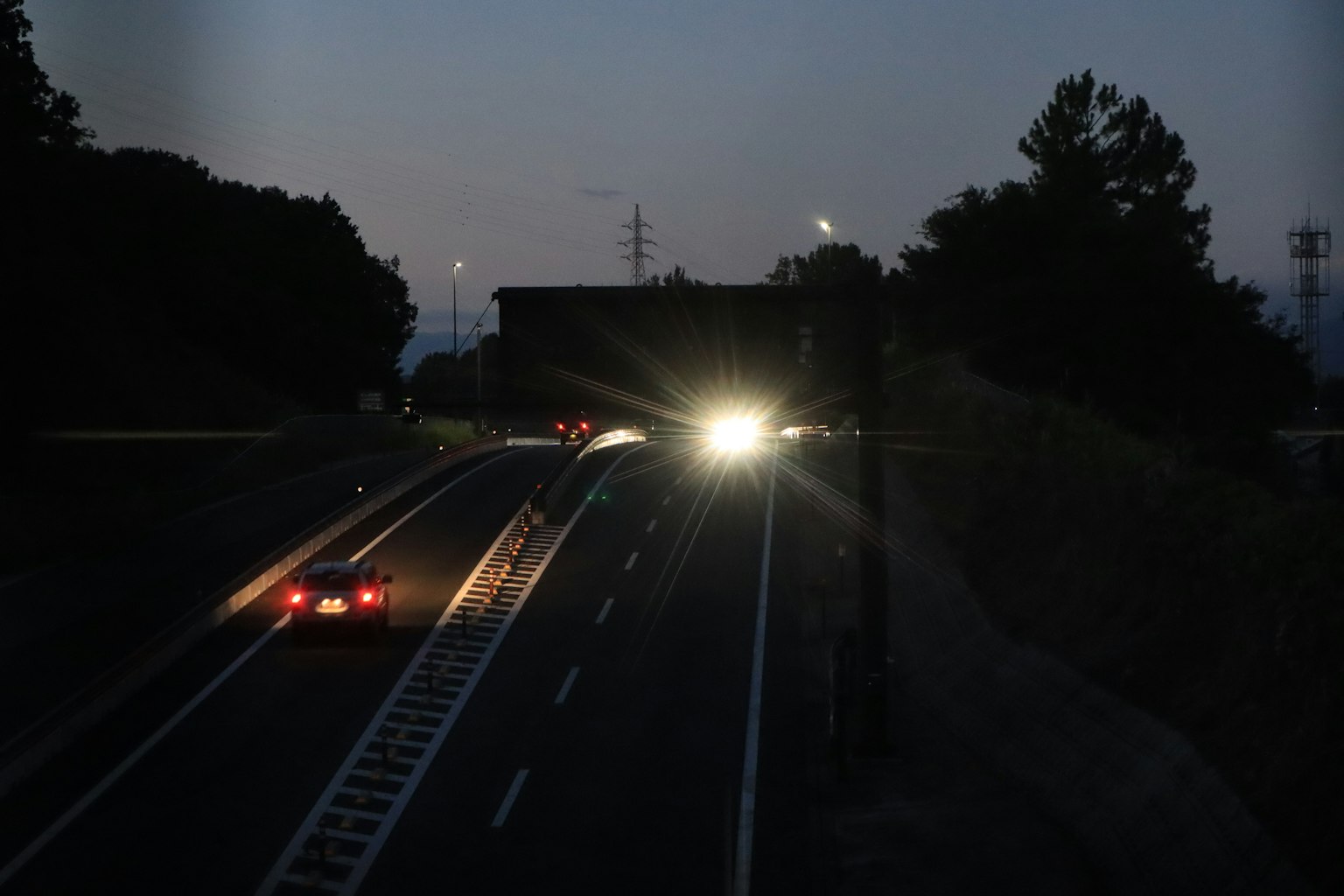Nächtliche Szene mit Autos und Scheinwerfern auf einer Straße