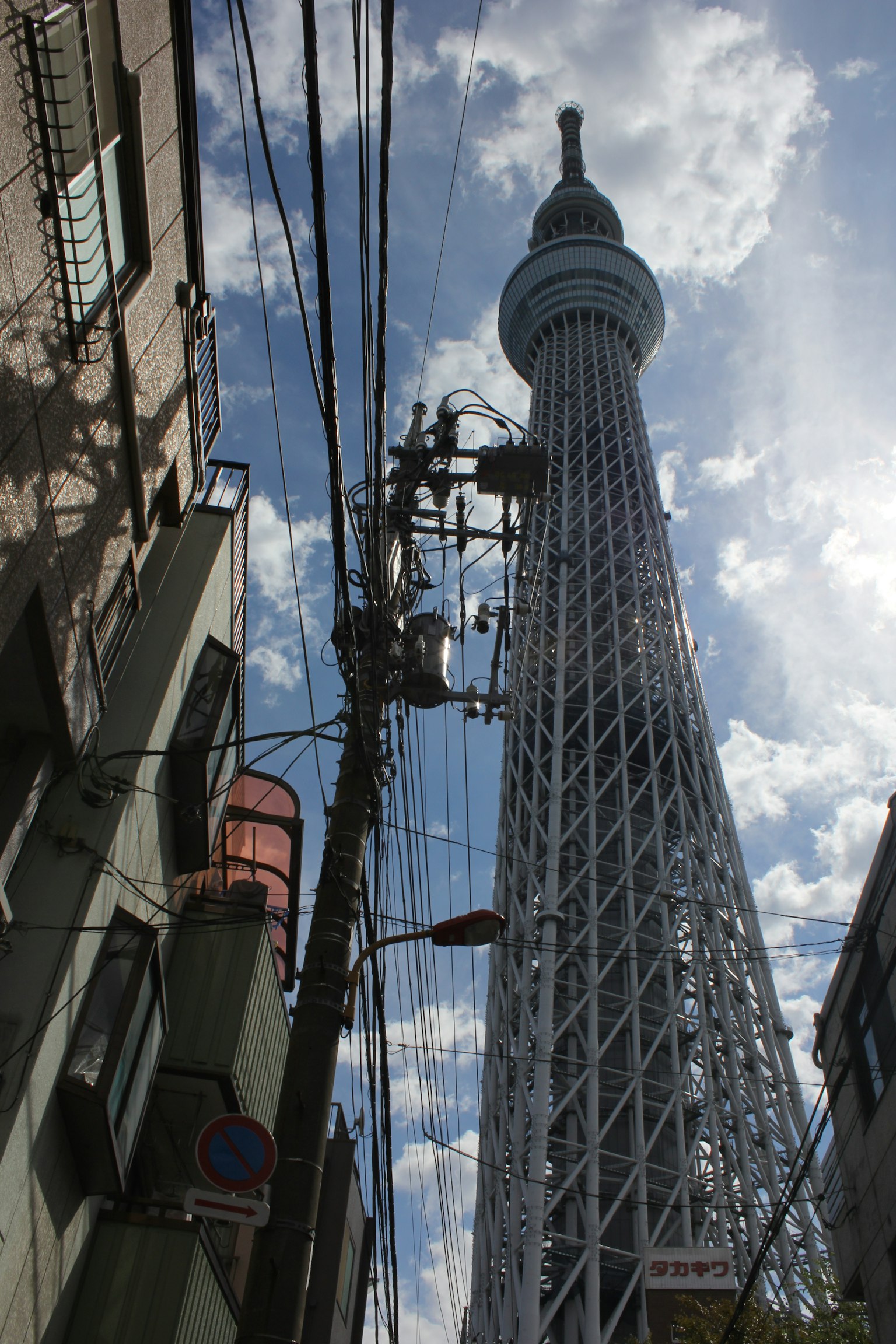 Tall Tokyo Skytree with surrounding buildings and power lines