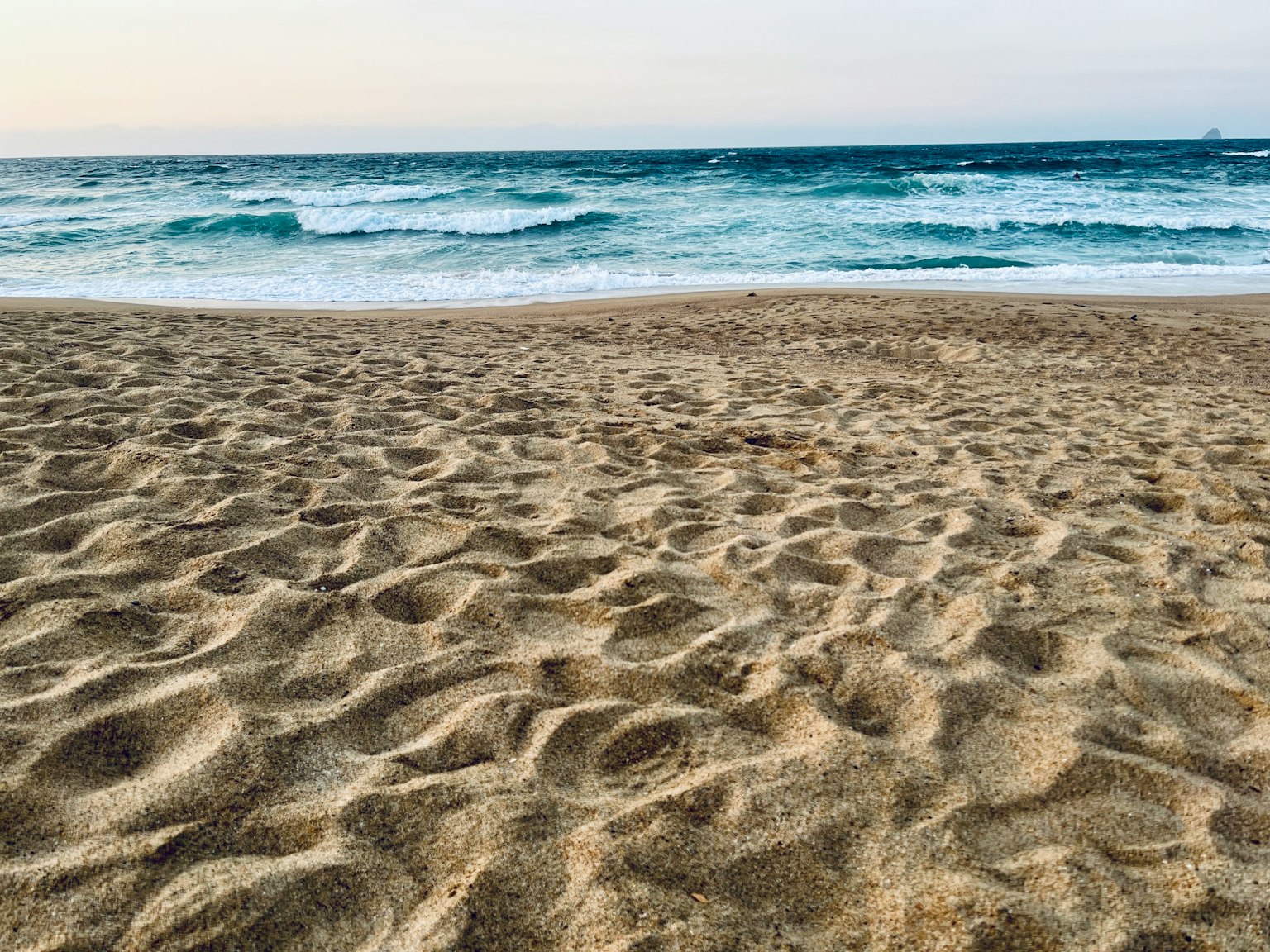 Pantai tenang dengan ombak lembut dan pantai berpasir