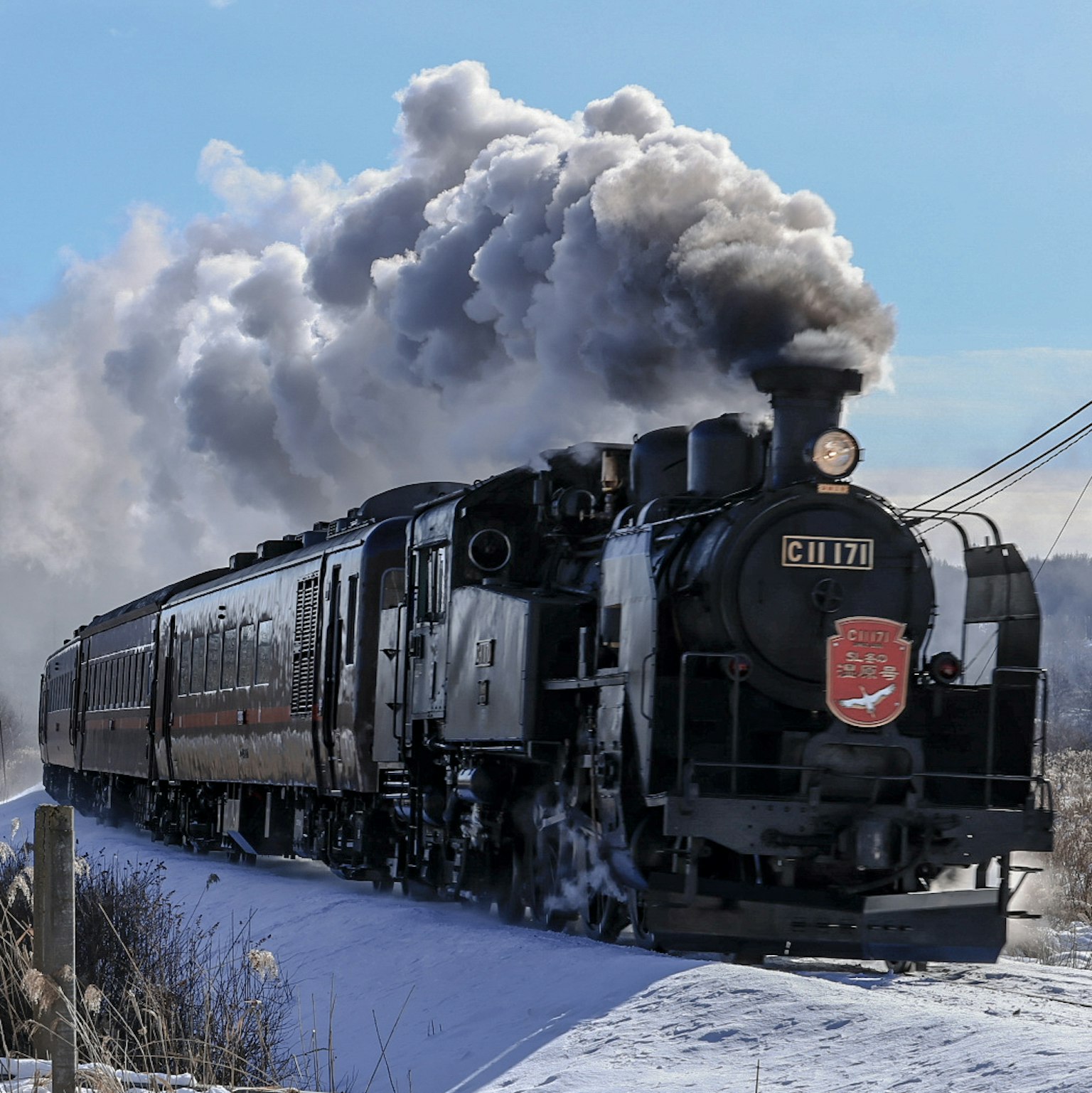 Dampflokomotive fährt durch eine verschneite Landschaft