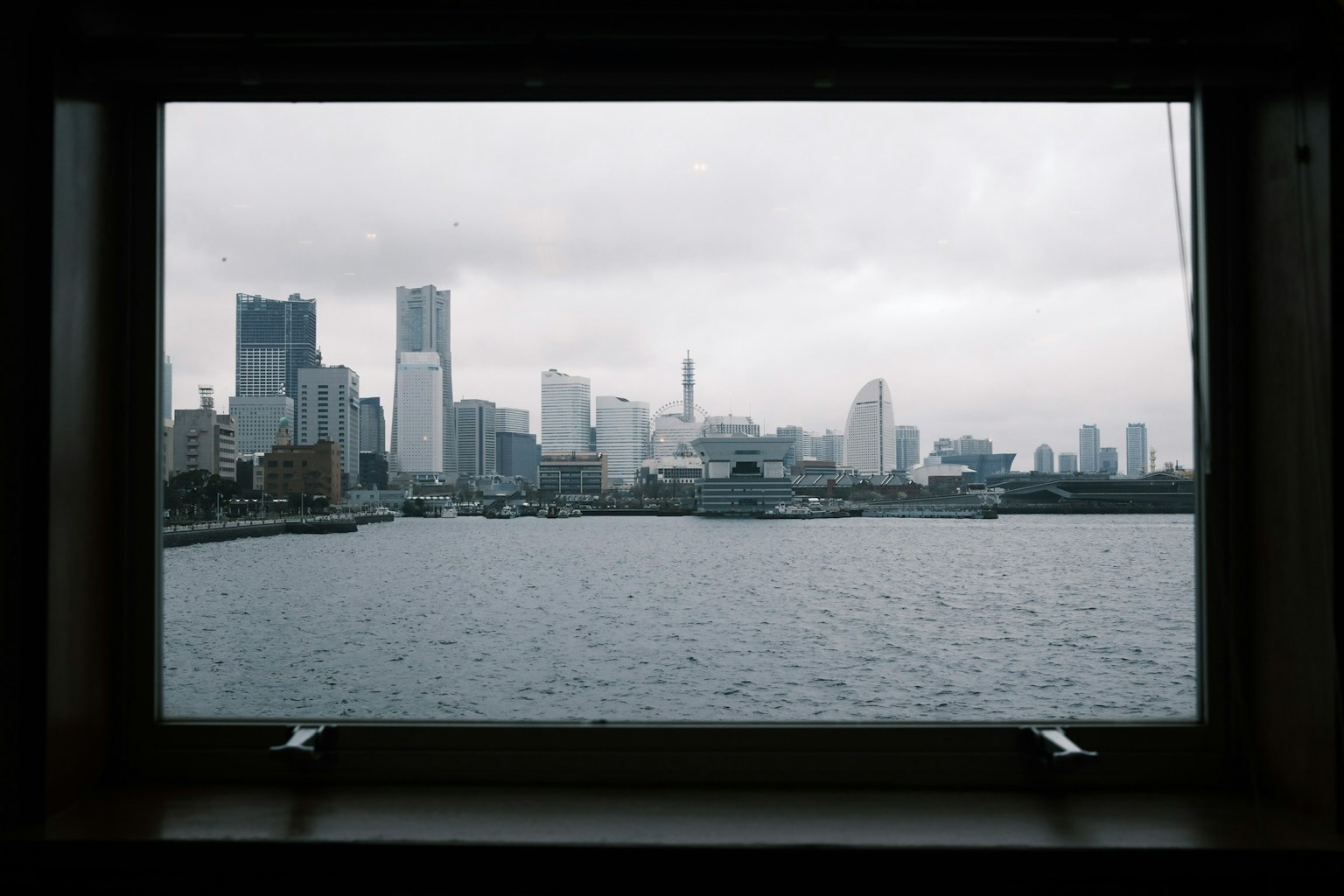 曇り空の下の東京の高層ビル群が見える窓からの眺め