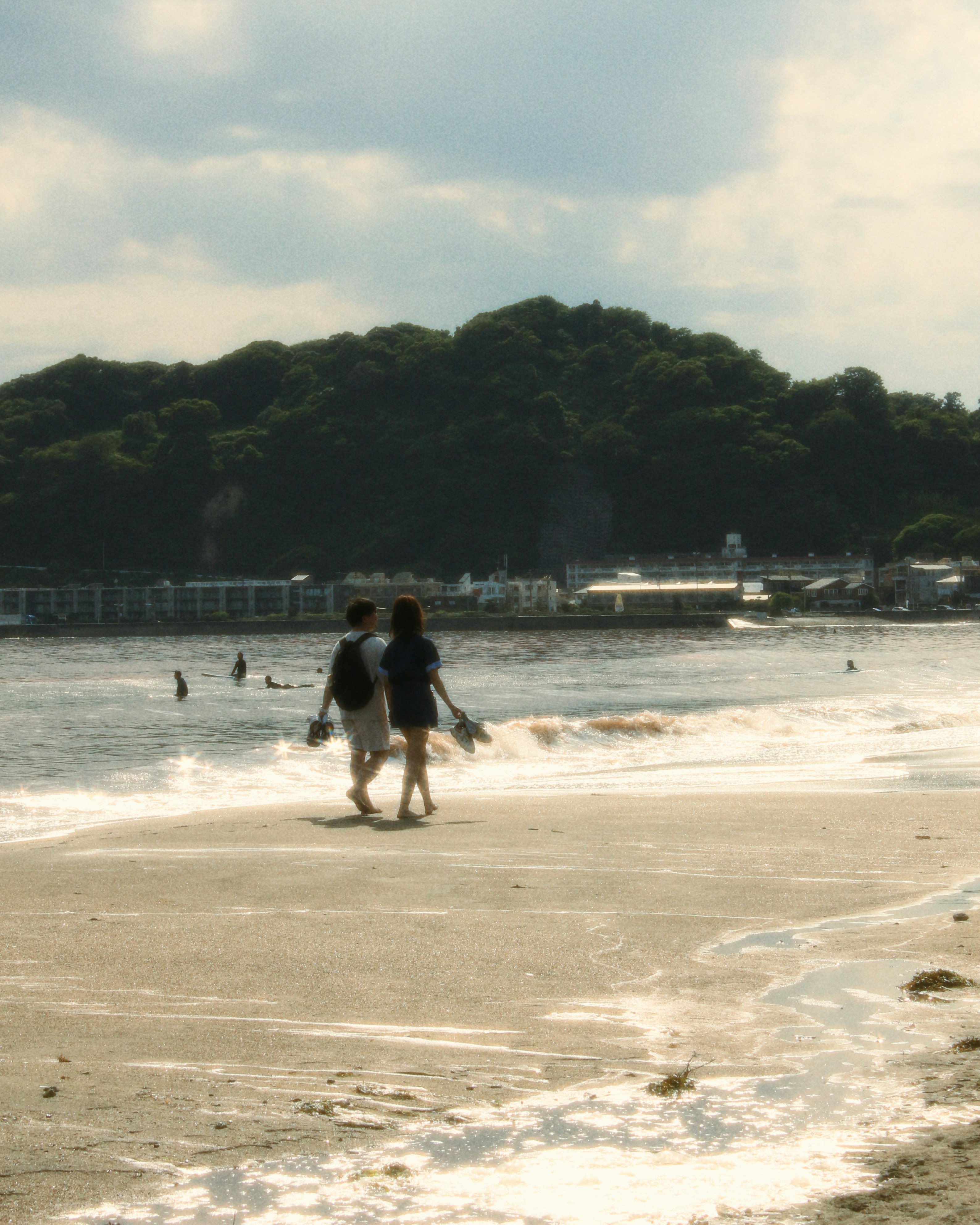 鎌倉の海辺で歩く人々と波打ち際の風景
