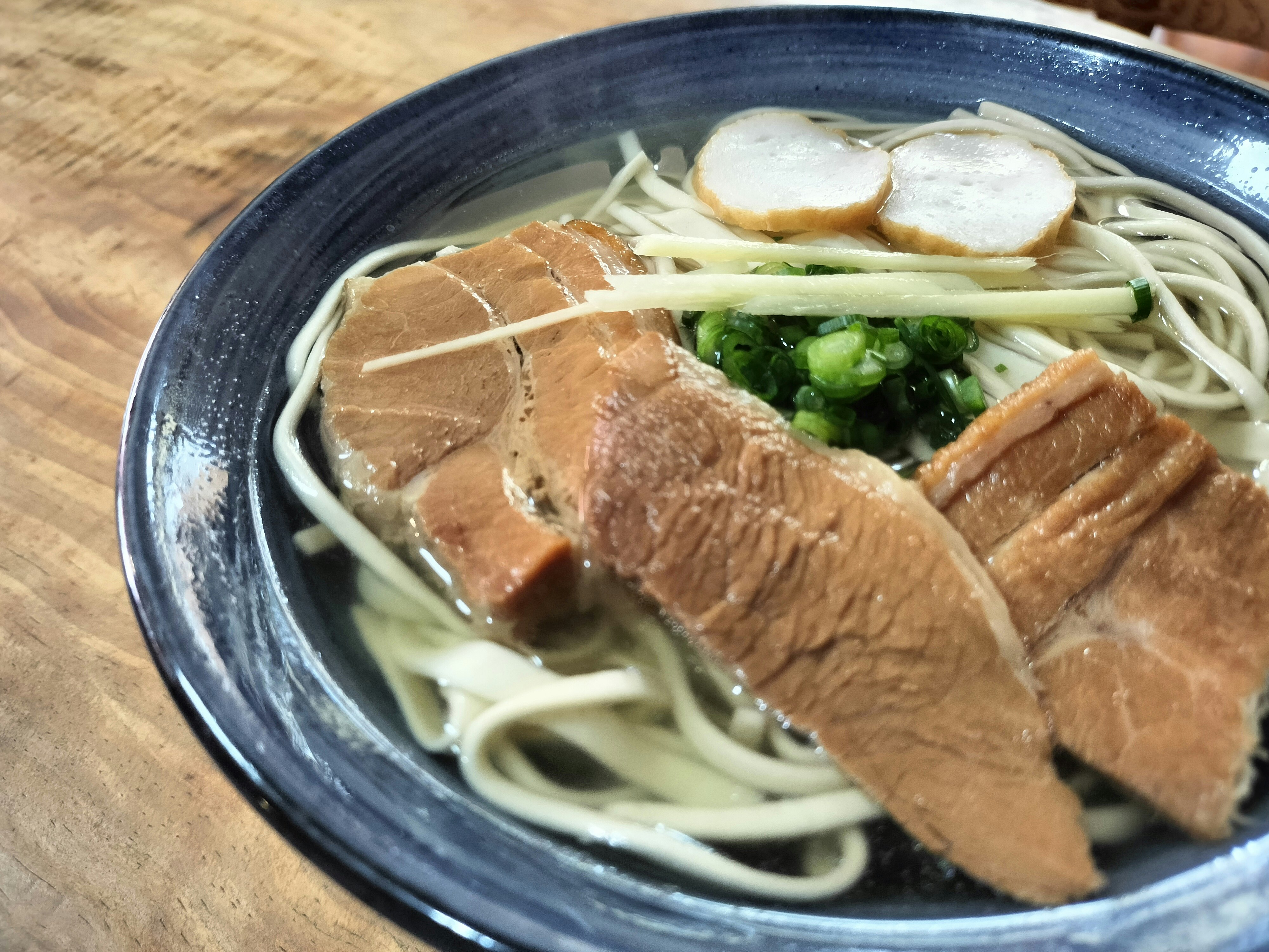 Bol d’okinawa soba avec nouilles, porc et oignons verts émincés
